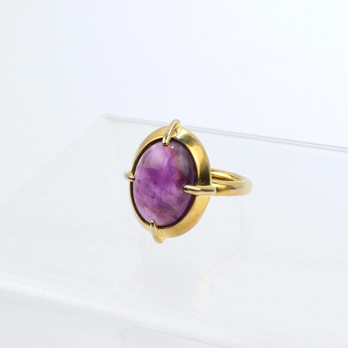 A very fine 14k gold and amethyst Bishop's ring.

With a large oval amethyst cabochon prong set in 14 karat gold. 

The ring's shank is a thick round band that mirrors the broad edge of the setting.  

The historical Byzantine design is based on a