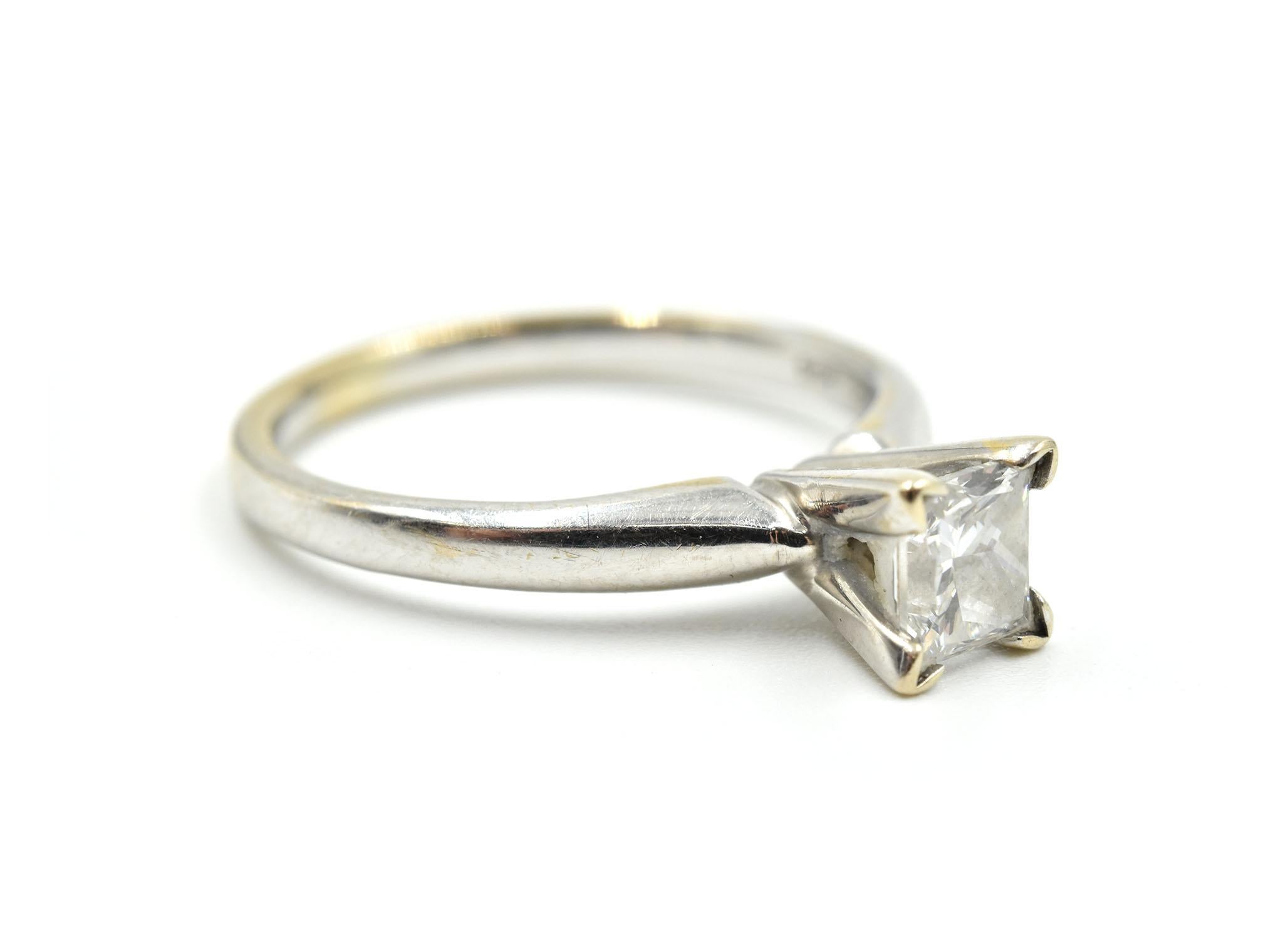 This classic engagement ring features a princess-cut diamond set into a 14k white gold mounting. The diamond weighs 0.63ct, and it is graded I in color and SI1 in clarity. The ring measures 6mm wide, and it weighs 3.2 grams. It is size 5.25.
