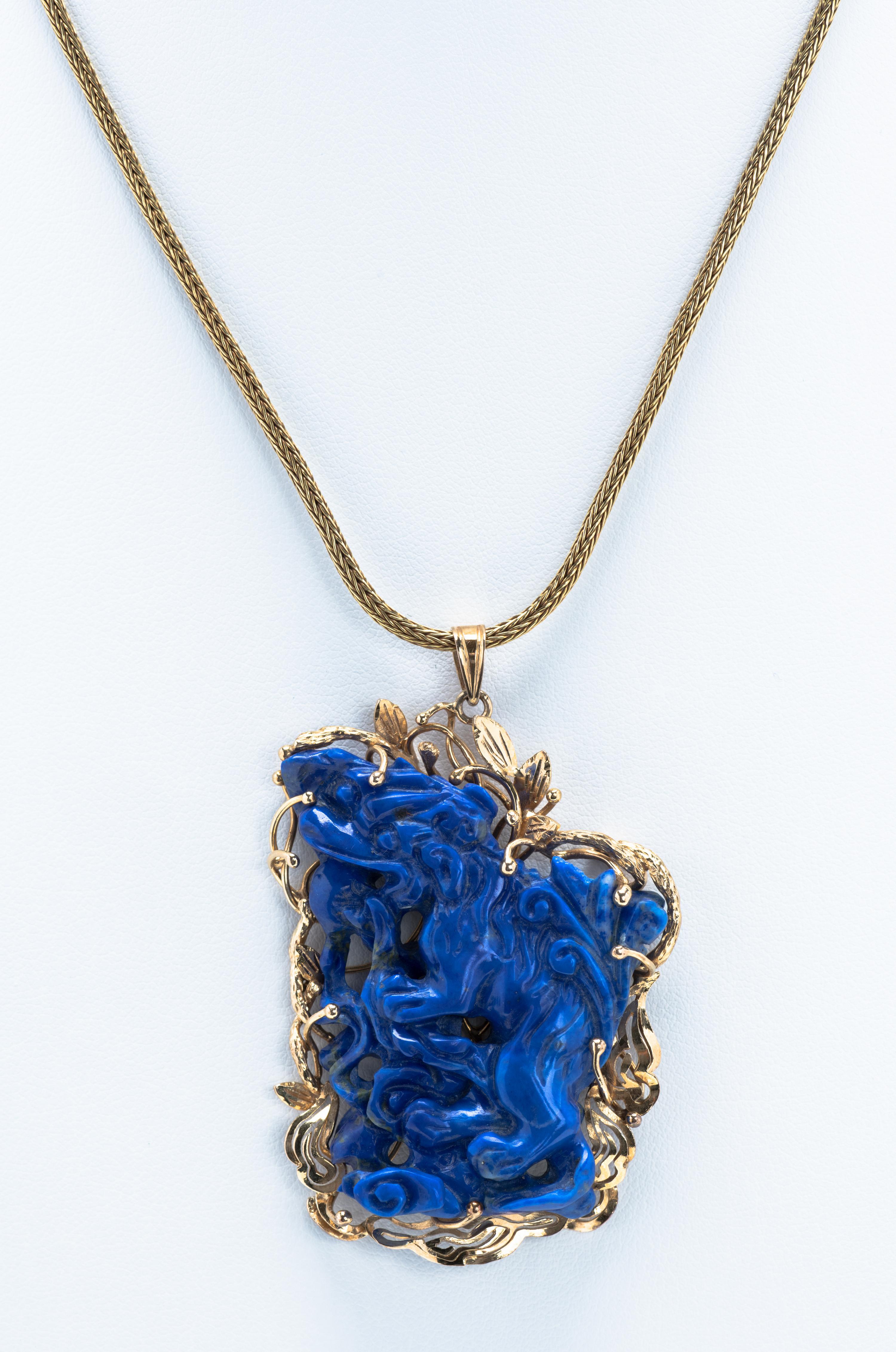 Carved lapis lazuli allegorical lion pendant set in 14 karat gold.

Note: Chain not included.

Size: L 2.25