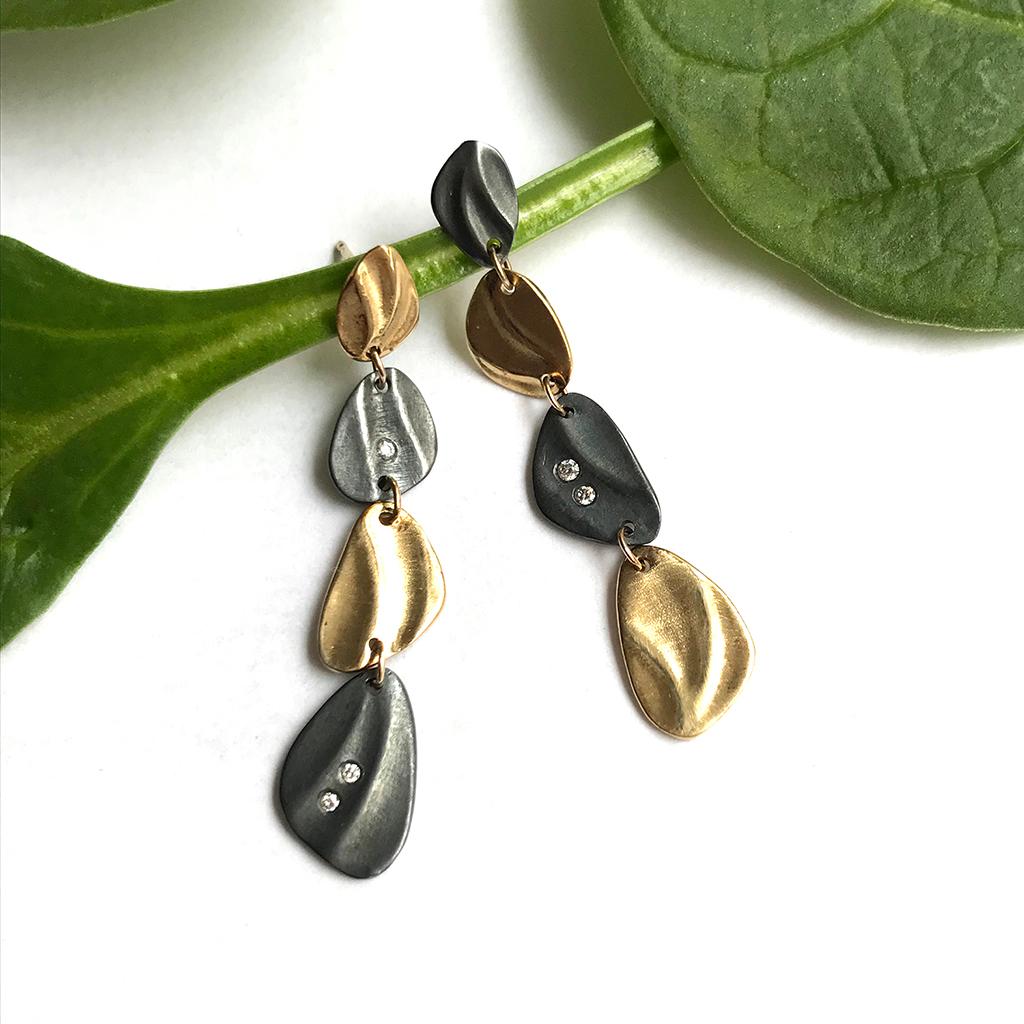 K.Mita's modern Mini Pebble Dangle Earrings from her Sand Dune Collection are handmade by the artist from 14 Karat Yellow Gold and Oxidized Sterling Silver. The contemporary earrings, which are 46 mm long and 8.5 mm wide, are accented with three