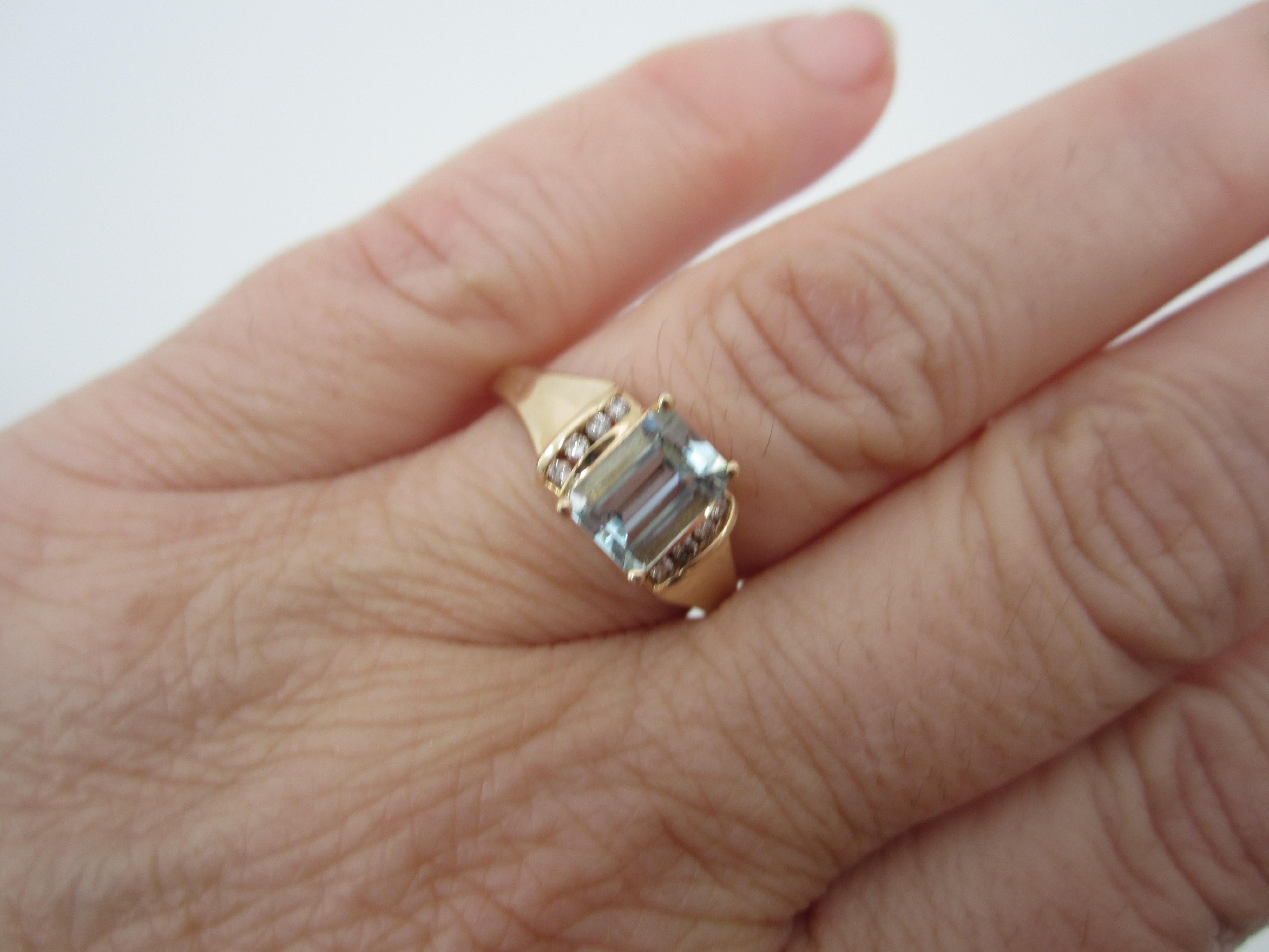 Modern in design, clean diamond accents on either side of the emerald cut aquamarine approximately 1.2 Carats. Diamonds adding up to approximately a 1/4 carat.  Ring is a size 9 and can be sized by us or your jeweler. Would be a lovely engagement