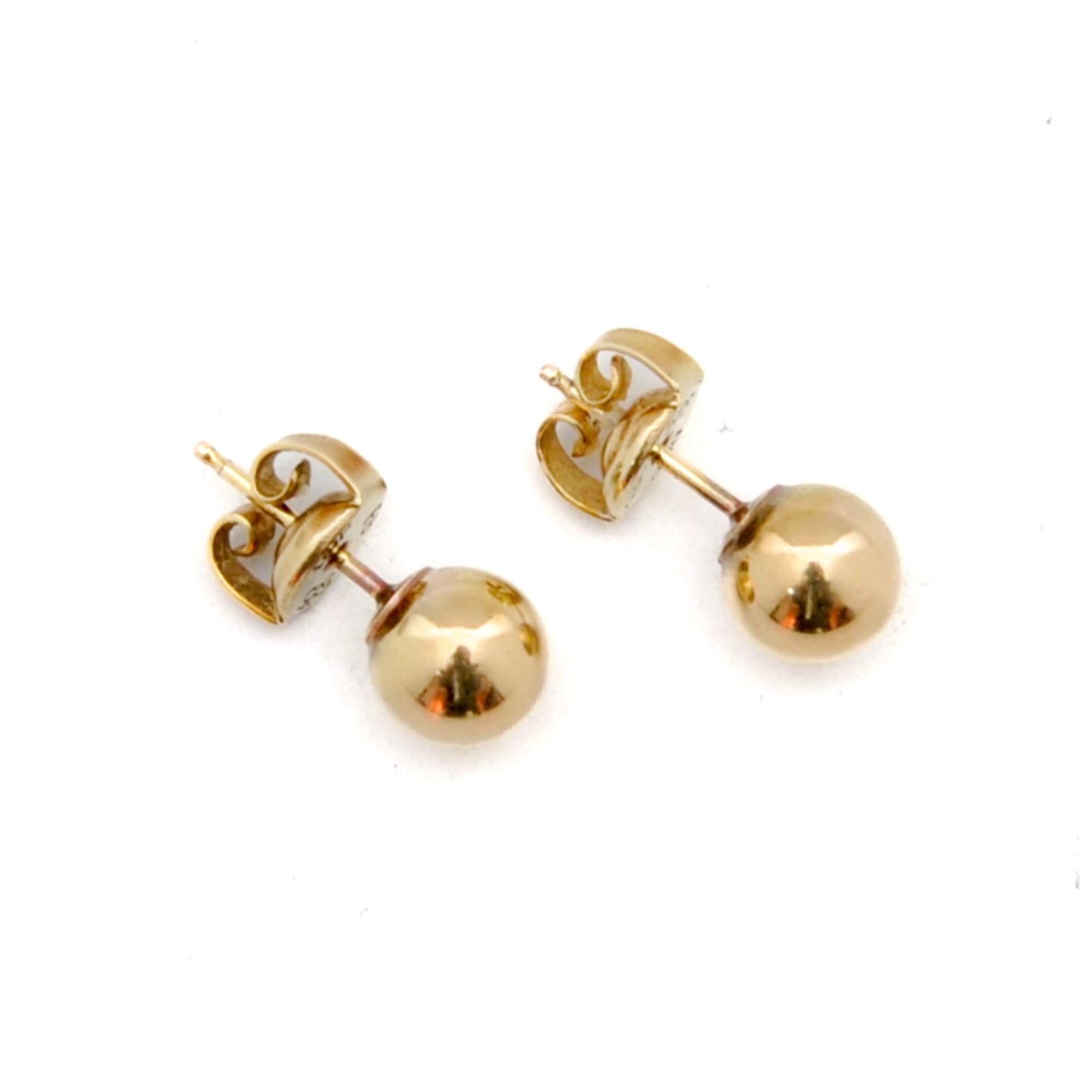 A beautiful vintage pair of classic round gold ball stud earrings. The smooth polished design of these round balls are created in 14 karat gold. The gold stud earrings are provided with a push back closure. The push backs are stamped with the 585