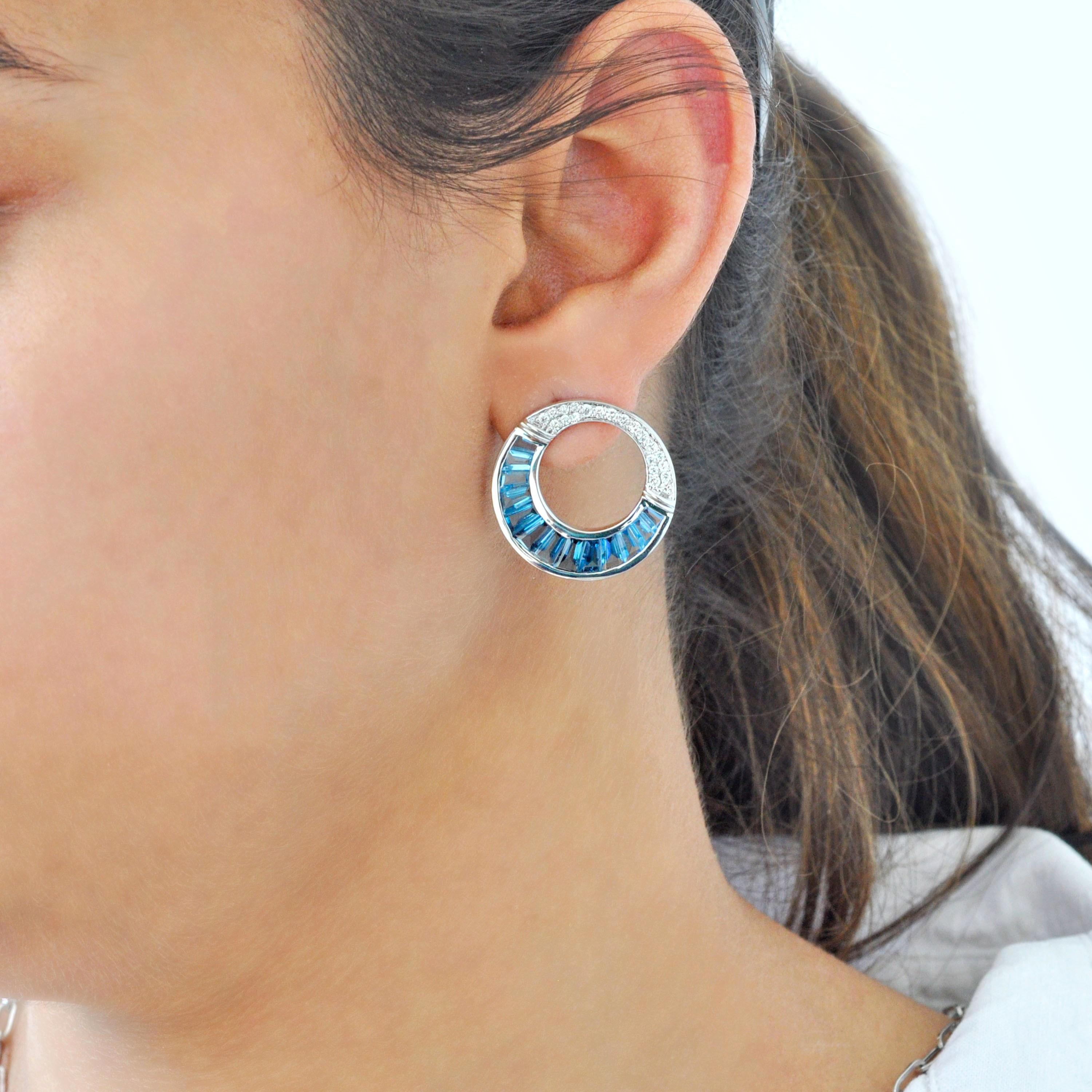 Elevate your everyday elegance with these 14K gold calibre-cut blue topaz circular stud earrings, where precise craftsmanship meets serene sophistication. Each earring features a radiant arc of tapered baguette blue topaz, arranged in a smooth