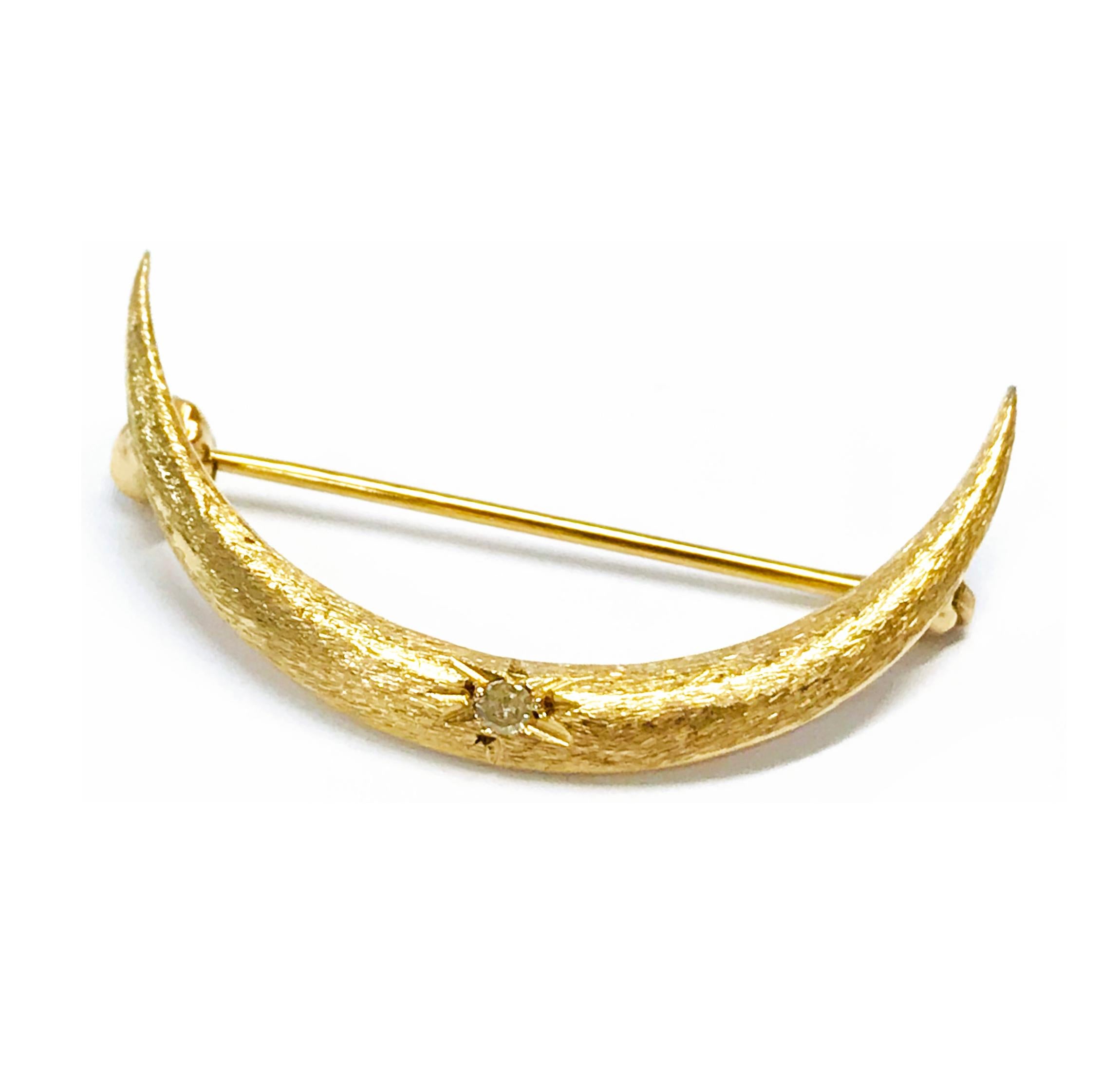 14 Karat Gold Diamond Crescent Moon Brooch/Pin. This is a simple and delicate yet sophisticated brooch/pin. The moon has an overall satin finish with a diamond set in the diamond-cut starburst center. The total diamond weight is 0.02ct. The