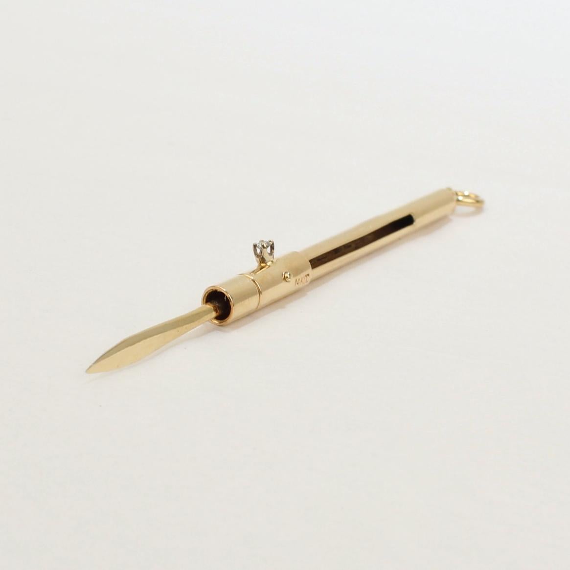 A fine and rare vintage retractable tooth pick.

In 14k gold and set with a prong set diamond functioning as its tab handle.

The toothpick is set with a bail and jump ring and is meant to be suspended from a chain.

A fun and whimsical