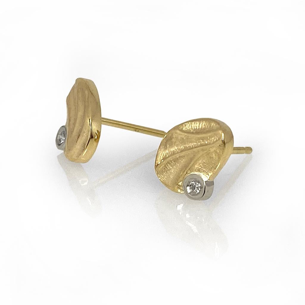 K.Mita's modern Dune Pebble Studs are handmade by the artist from 14 Karat Yellow Gold.  The contemporary earrings, which are 9 mm long and 7 mm wide, are accented with Diamonds (0.02 Carats total weight) set in 14 Karat White Gold Bezels and have