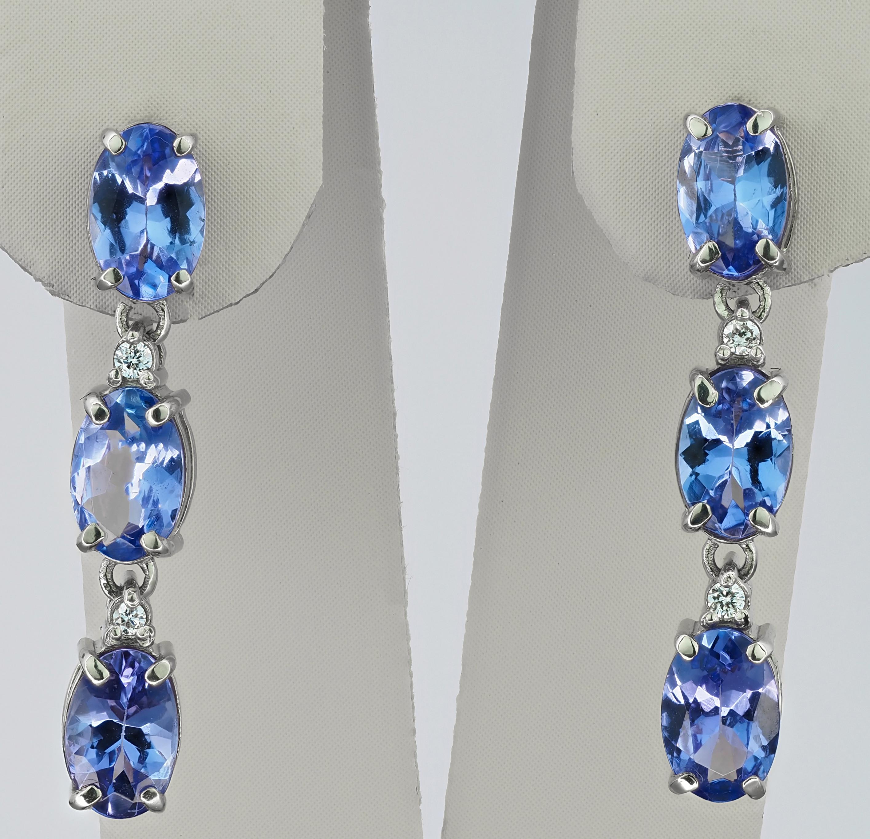 14 karat solid gold earrings with central genuine tanzanite and diamonds. December birthstone.
Weight: 2.5 g.
Size: 23 x 4.5 mm.

Gemstones: Natural tanzanites - 6 pieces
Weight: approx 4.00 ct in total, oval cut, color - blue light
Clarity: