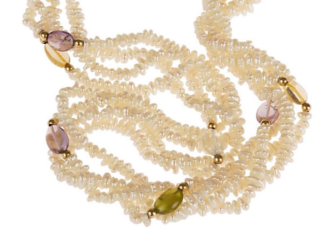 Handmade necklace featuring freshwater pearl, citrine, amethyst, peridot, aquamarine, and 14 karat gold beads. Dates from 1960's. Stones measure 9mm by 6mm each. Endless with no clasp, may be worn full-length or double looped.
