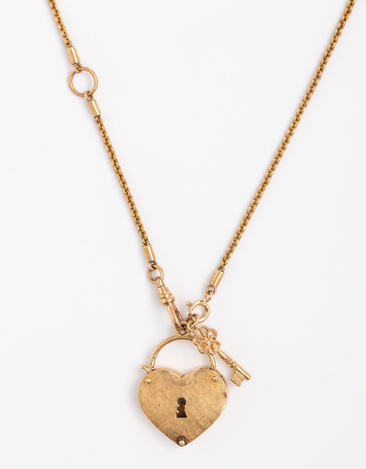 Large mid-20th century padlock gold heart with key necklace in 14 karat gold on early Art Deco watch chain in 14 karat. The clasp is found in the front while heart itself is in brushed gold. The heart pendant measures 1.00 Inch wide and 1.25 Inches