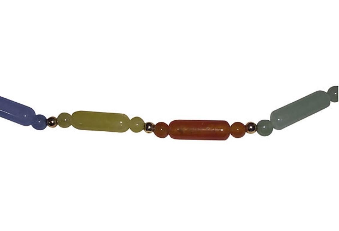 Natural jadeite necklace colors include: light green, cinnamon, yellow, blue, purple, black, white, and 14 kt yellow gold marquise clasp and ball beads. Necklace is 18