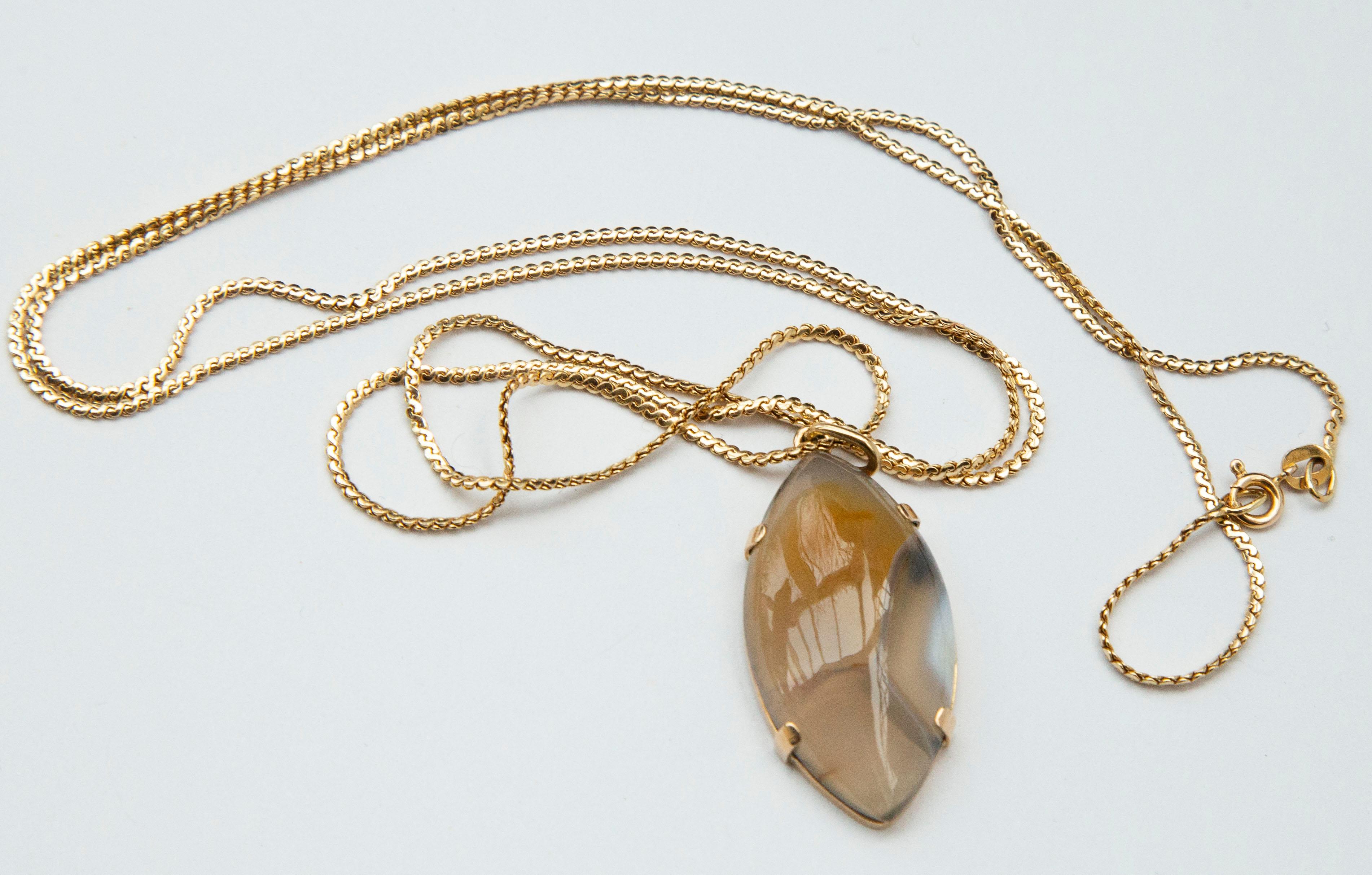 A vintage 14 karat yellow gold necklace chain with an agate pendant in 14 karat yellow gold setting.

The necklace chain is 80 CM / 32 Inch long and it weighs 7.7 grams. It is marked with 585 that stands for 585/14 karat gold content.
The pendant is