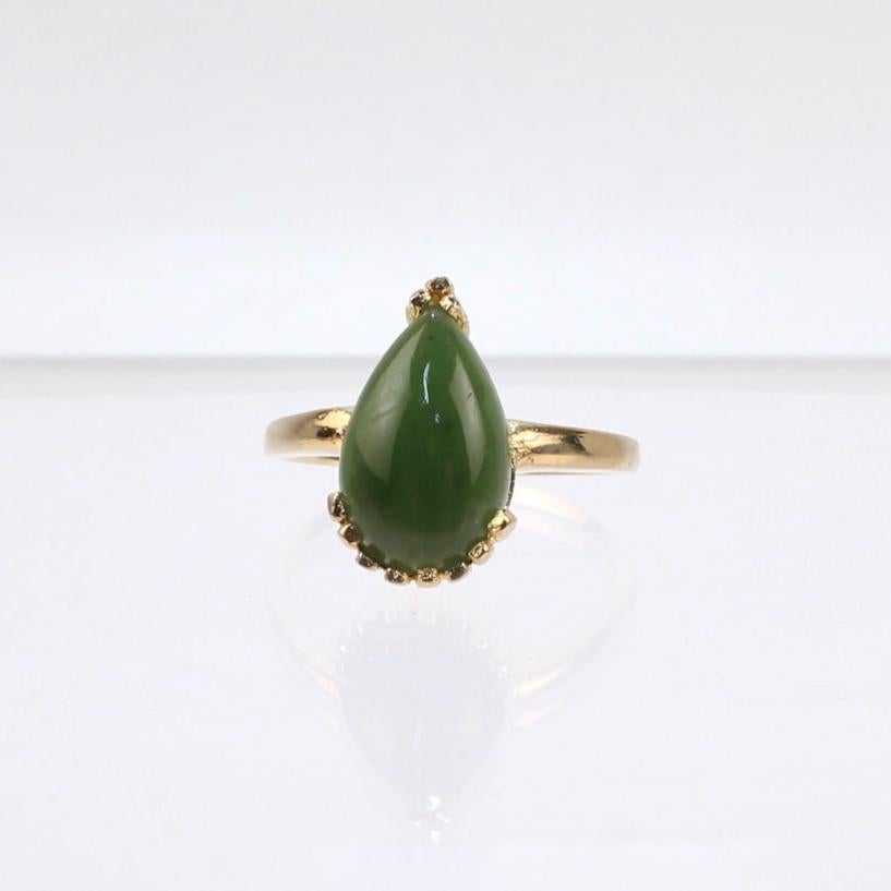 A very fine 14k gold and nephrite jade ring.

With a pear shaped smooth nephrite jade cabochon that is prong set in a 14k gold clam shell like setting.

A refined and beautiful ring!

Date: 
20th Century

Overall Condition:
It is in overall good,