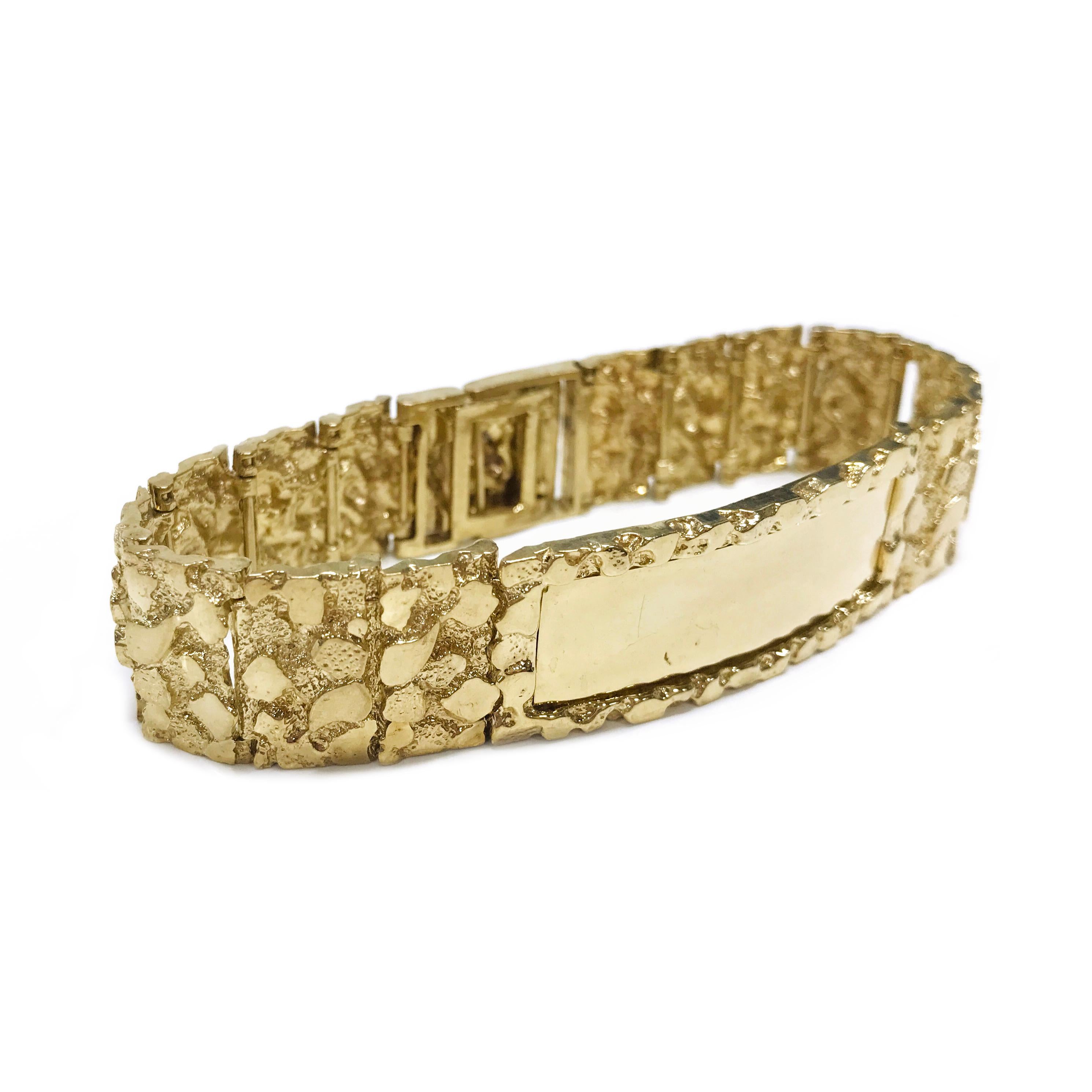 14 Karat Gold Nugget ID Bracelet. The bracelet features fourteen nugget textured links with a rectangular ID link center. The center smooth area is engravable. Stamped on the inside of the clasp is 14K. The bracelet is 8.5