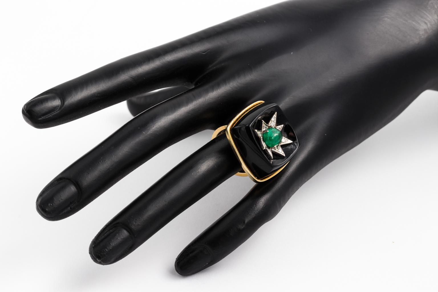 A Mid-Century ring in square shape consisting of raised onyx and in center of stone a diamond star with a cabochon approx. 1ct emerald. 14kt Gold frame. 