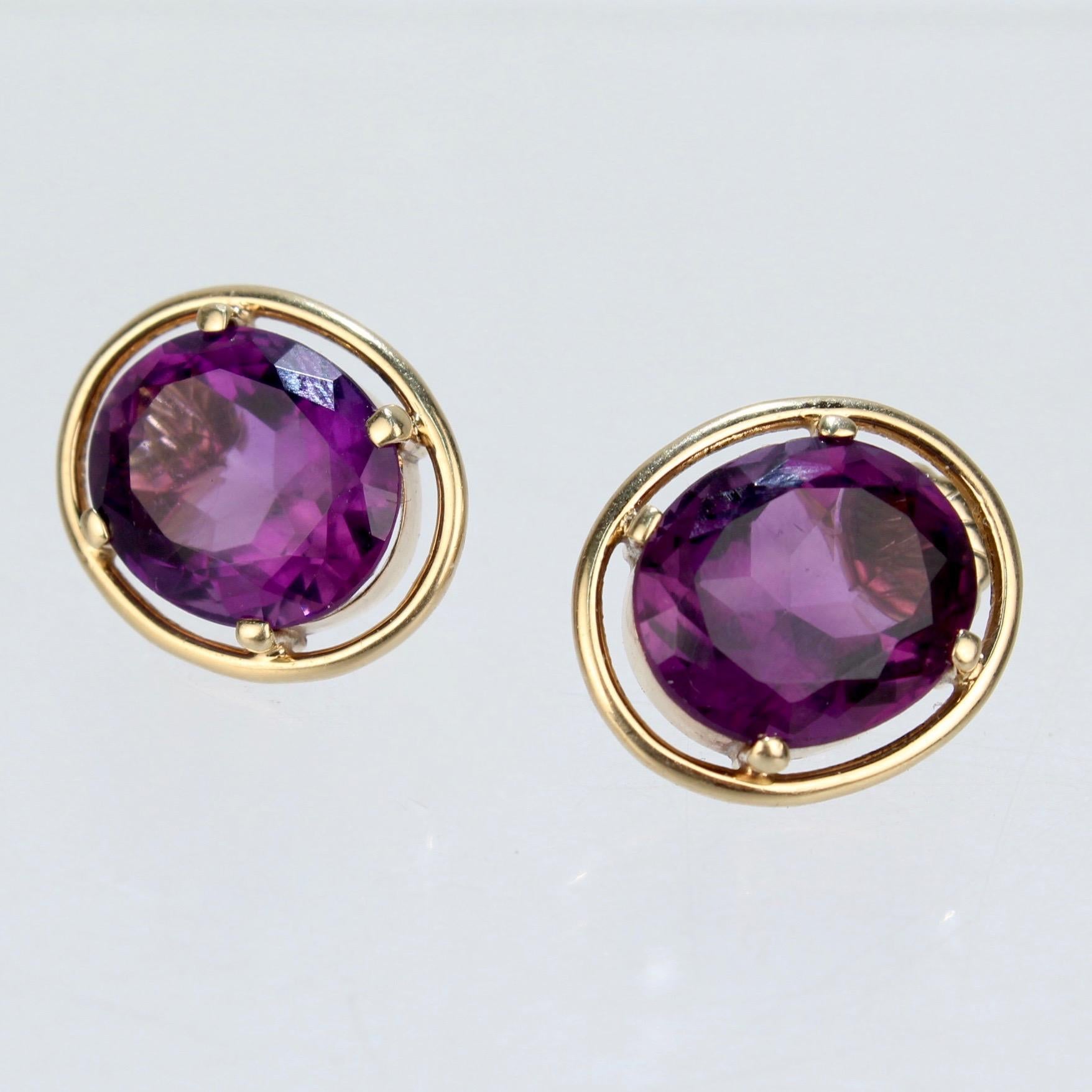 A fine pair of 14k gold and purple spinel earrings.

With gorgeous oval-cut purple spinel gemstones prong set in a gold mount and encircled by a gold ring. 

Simply a wonderful pair of earrings!

Width: ca. 15mm
Length: ca. 18 mm
Spinel Width: ca.