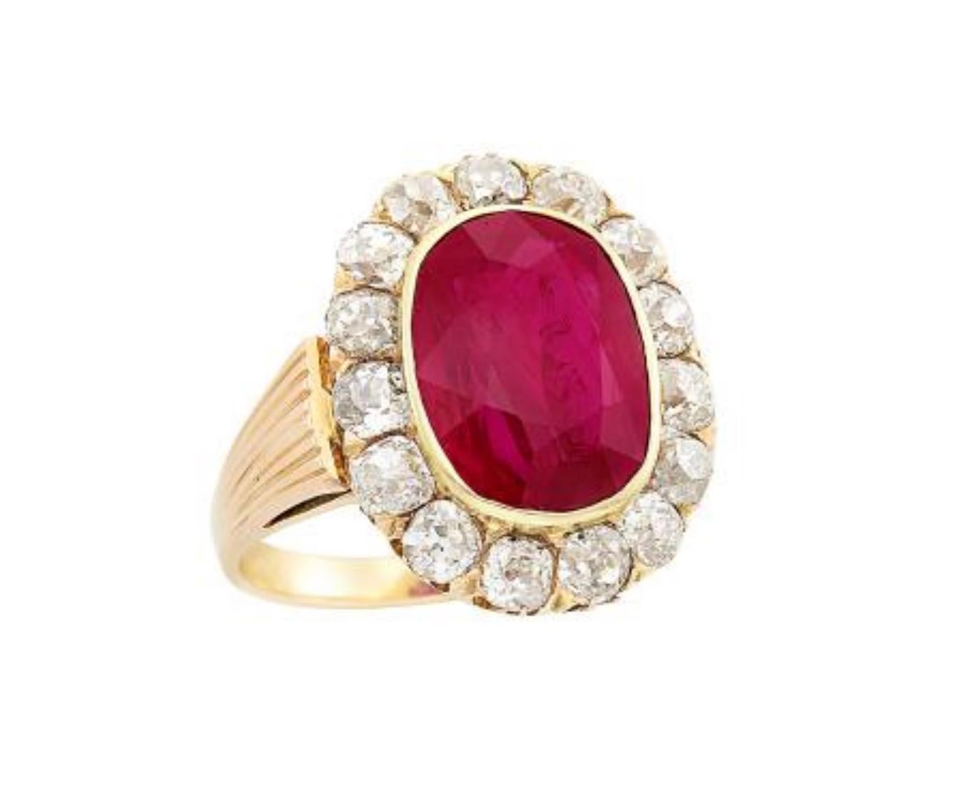 14 kt., centering one oval ruby approximately 7.50 cts., surrounded by 15 old-mine cut diamonds approximately 2.00 cts., approximately 5.8 dwts. Size 7 1/4  Ruby: vivid raspberry red, very good color concentration, moderately included, several