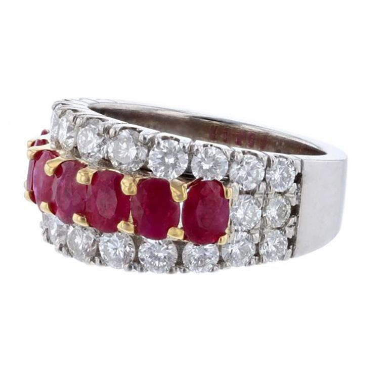 This ring is made in 14K white and yellow gold and features 7 Oval Shape Rubies weighing 2.01 carats. The ring also features 26 round cut, prong set white diamonds weighing 1.79 carats with a color grade (H) and clarity grade (SI2). 
