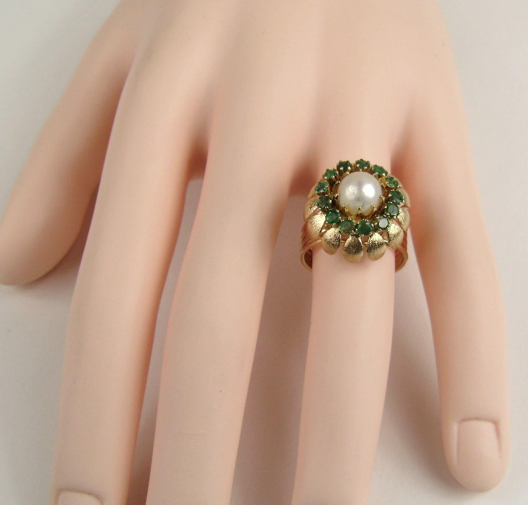 14K gold 1960s Cocktail ring. Very Mad Men! Center Pearl flanked with accent emerald stones. The ring sits up high (.50in) 4 ring open band with a flower motif setting. Ring is a size 7-1/4 and can be sized by us or your jeweler. Be sure to check