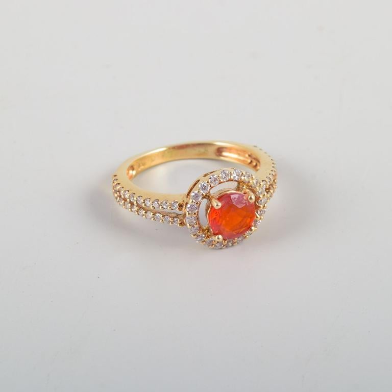 Bague en or 14 carats ornée d'une opale orange et de nombreux diamants taille brillant.