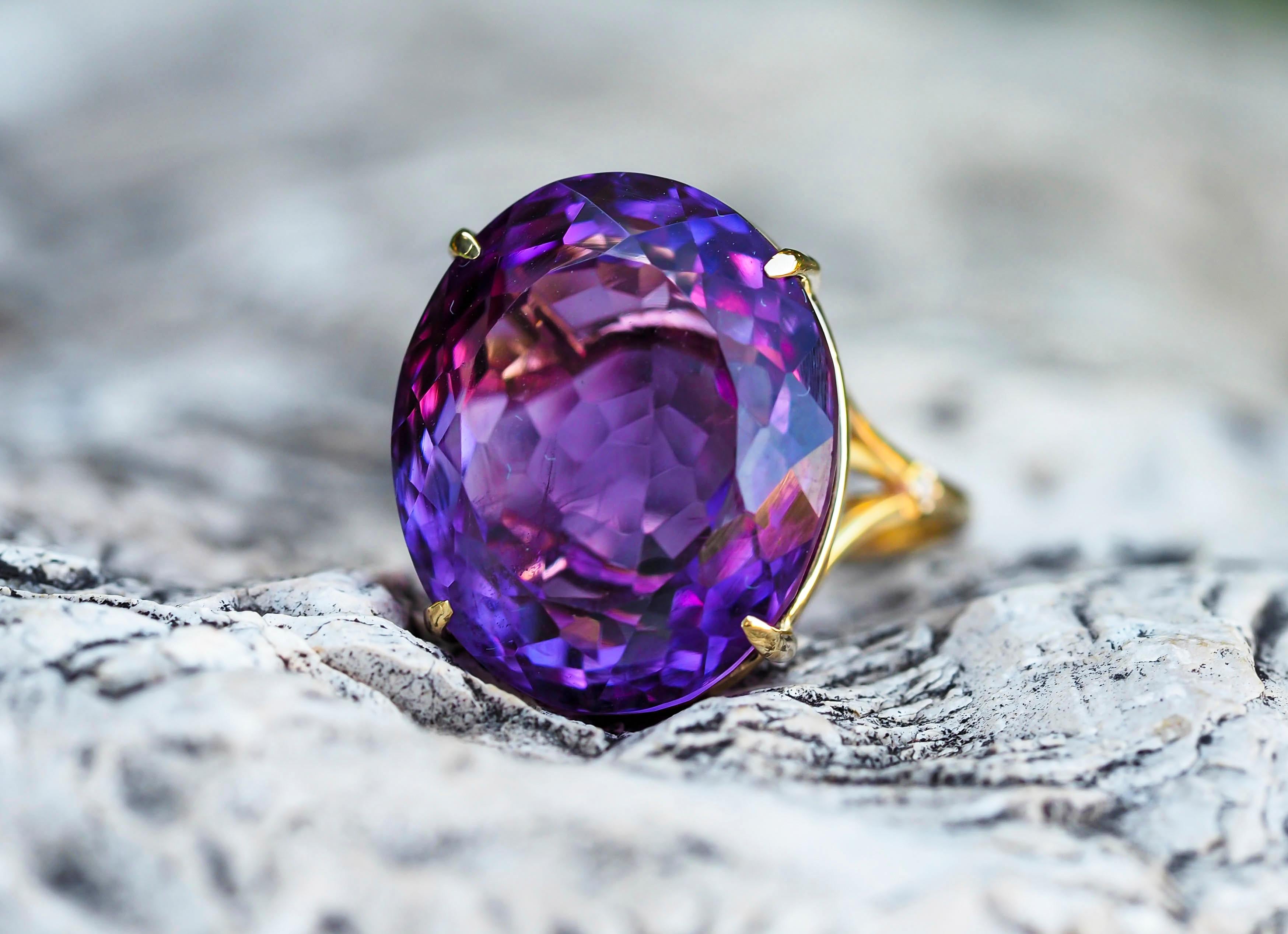 14 karat solid gold ring with genuine amethyst and diamonds. February birthstone.
Weight: 4 g. 
Size: 7 US
Central stone: genuine amethyst
Weight: approx 8 ct.
Color: violet, oval cut. 
Clarity: Transparent with inclusions.
Surrounding