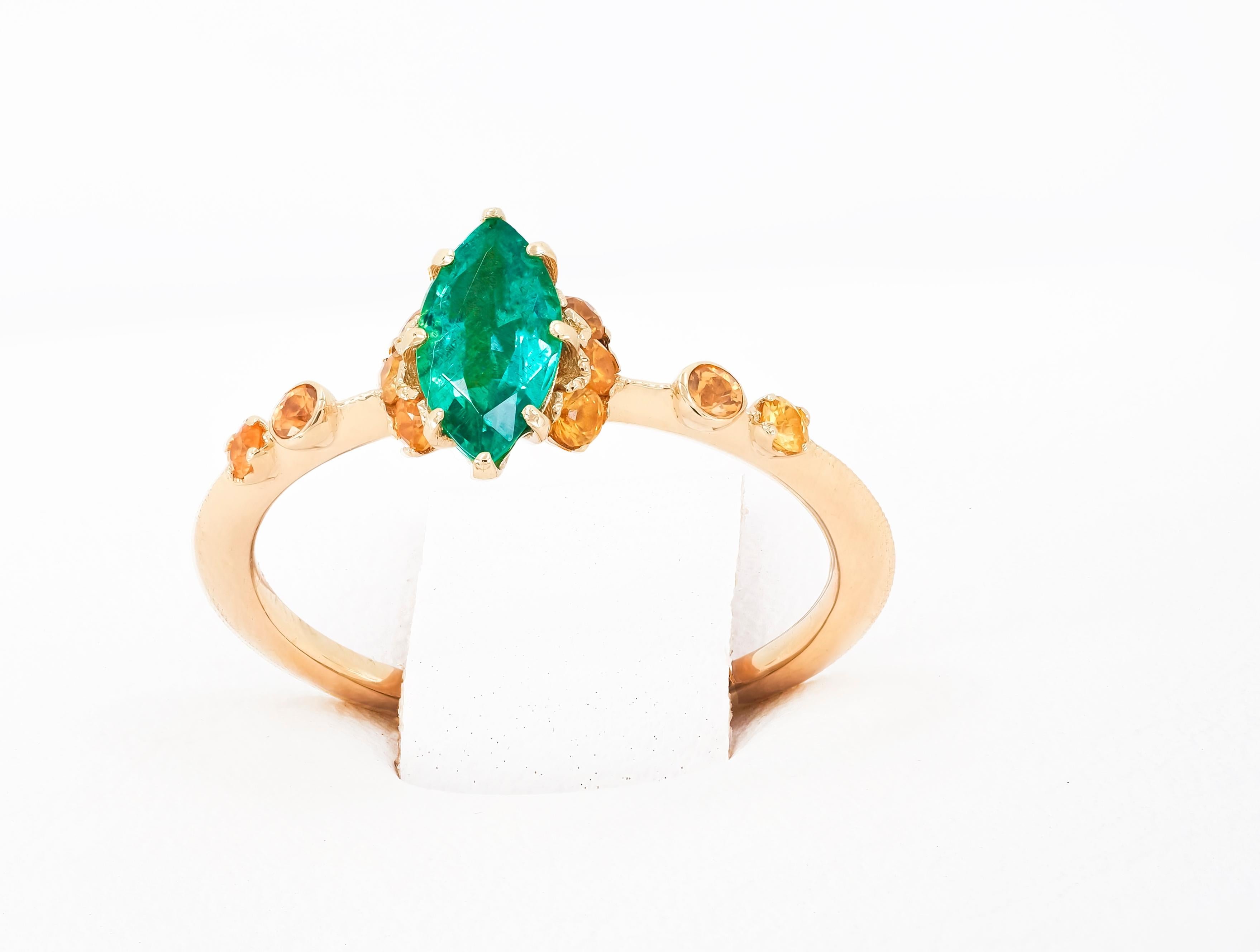 14 karat gold ring with genuine emerald and sapphires.
Metal: 14 karat gold
Weight: 1.65 g. 
Central stone: Genuine emerald
Color: Green  
Marquise cut, weight - 0.70 ct in total.
Clarity: Transparent with inclusions 
Surrounding stones:
Genuine