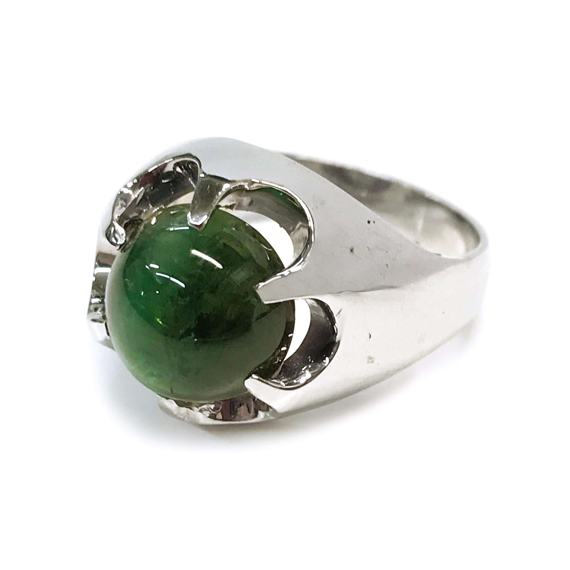 14 Karat White Gold Green Cat's Eye Tourmaline Cocktail Ring. The green Tourmaline cabochon measures 11.3mm and has an approximate weight of 14.0ct. The beautiful green hue set against 14k white gold creates a striking contrast. There is a prominent