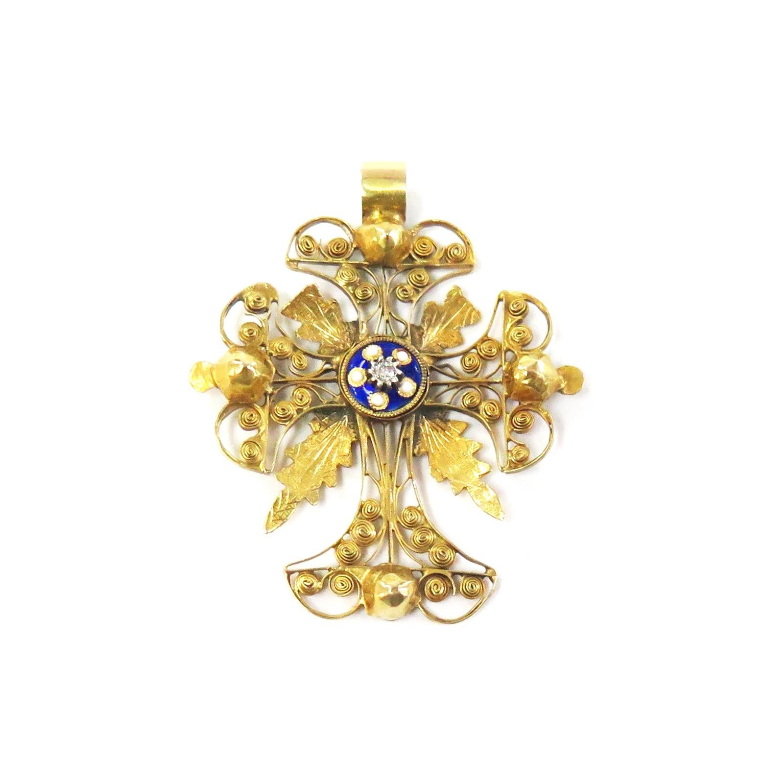 Beautiful detail on this 14 karat yellow gold handmade intricate filigree cross. The center is blue enamel with tiny white enamel dots. Inside the enamel is a silver setting with a tiny round diamond.

Length: 1 3/8