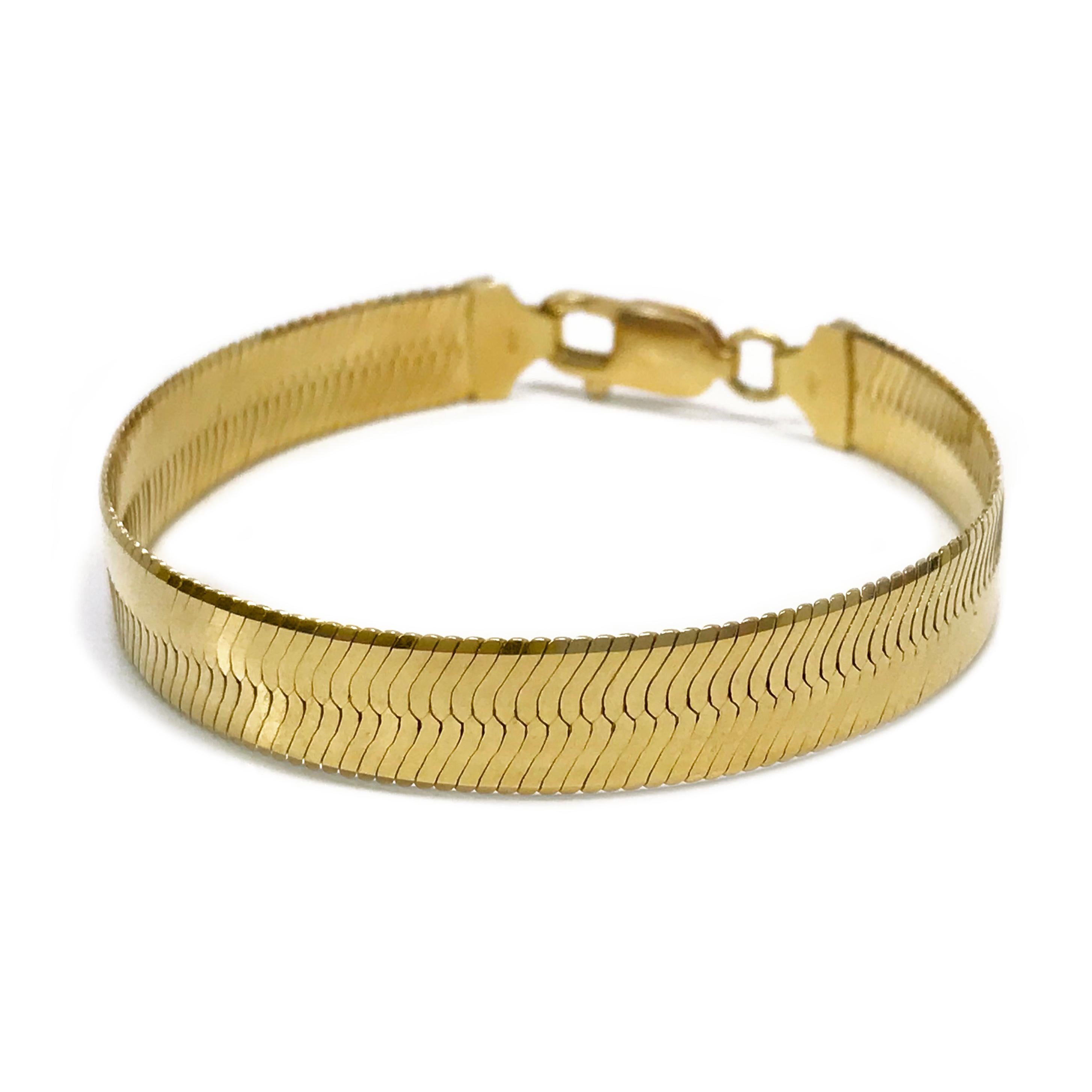 14 Karat Yellow Gold Herringbone Bracelet. The bracelet is 9mm wide. Stamped on the inside of the clasp is 750 ITALY. The bracelet is 7