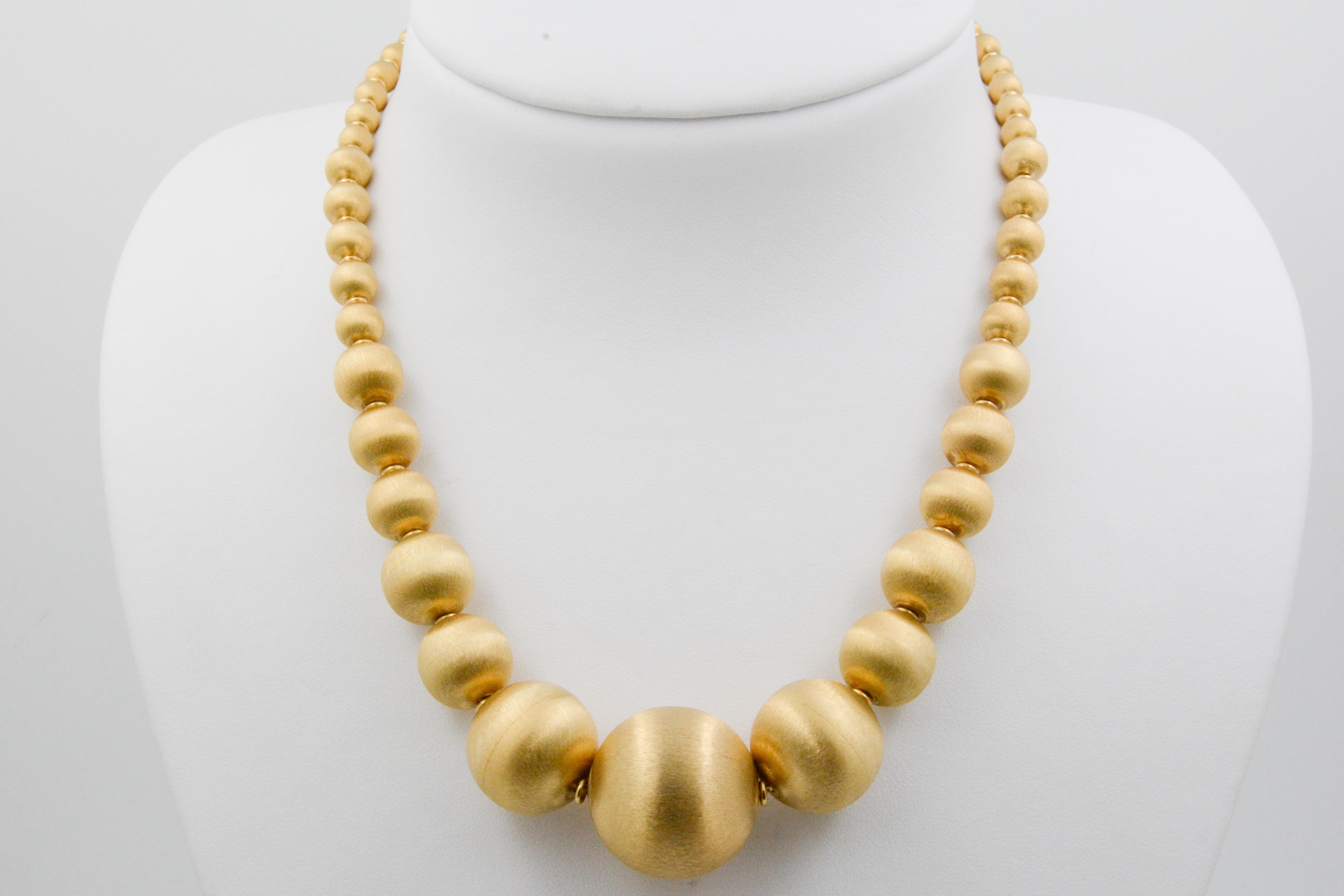 This 14K yellow gold graduated necklace is classic and elegant with shiny and smooth textured beads. The beads range from 24.02mm x 5.91mm in size across the neck. This simplistic style necklace encompasses the true meaning of Italy's craftsmanship,
