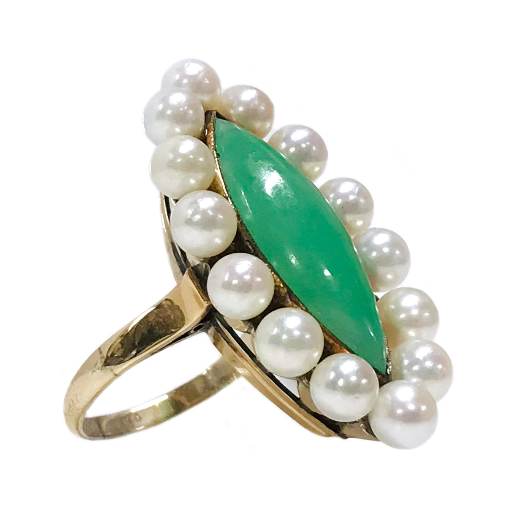 14 Karat Jade Pearl Navette Ring. The ring features a bezel-set green jade cabochon measuring 22 tall x 8.7mm wide. There are fourteen 4.5mm pearls set all around the center bezel. The pearls are creamy-white with good luster. Stamped on the inside