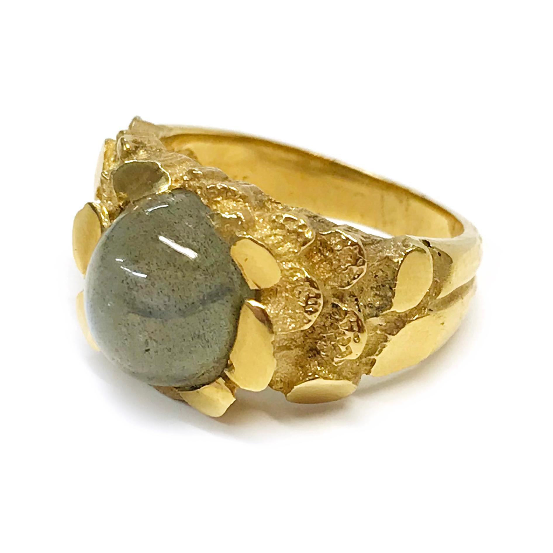 14 Karat Labradorite Nugget Ring. The ring features a bezel-set oval labradorite cabochon, the band is about nugget texture and the reminder is a smooth shiny finish. The labradorite is 16 carat and the ring size is 9. Stamped on the inside of the