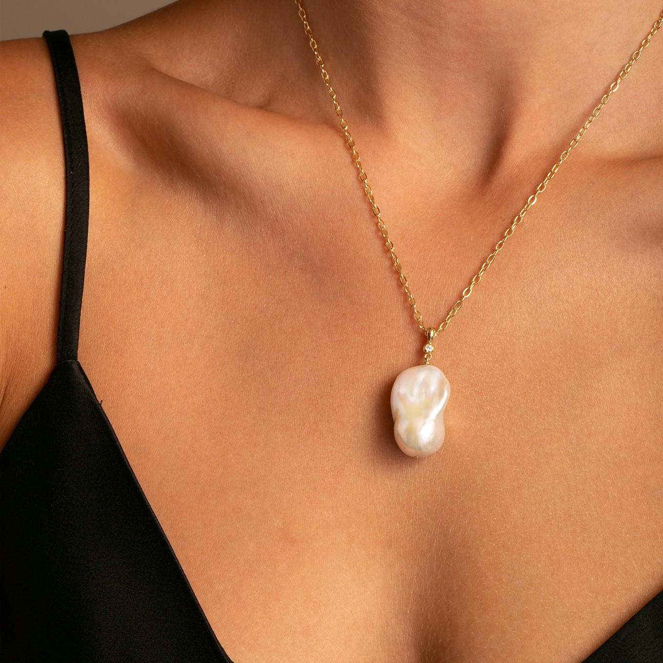 Stunning Large Baroque (14-17mm) Pearl  with a sparkling Bezel Set diamond set in 14k high polish yellow gold, with 18 inch cable chain.

Diamond - 1 Round Sparkling 2mm G/SI1 color. (.03ctw)

A modern update on the classic pearl pendant – simple