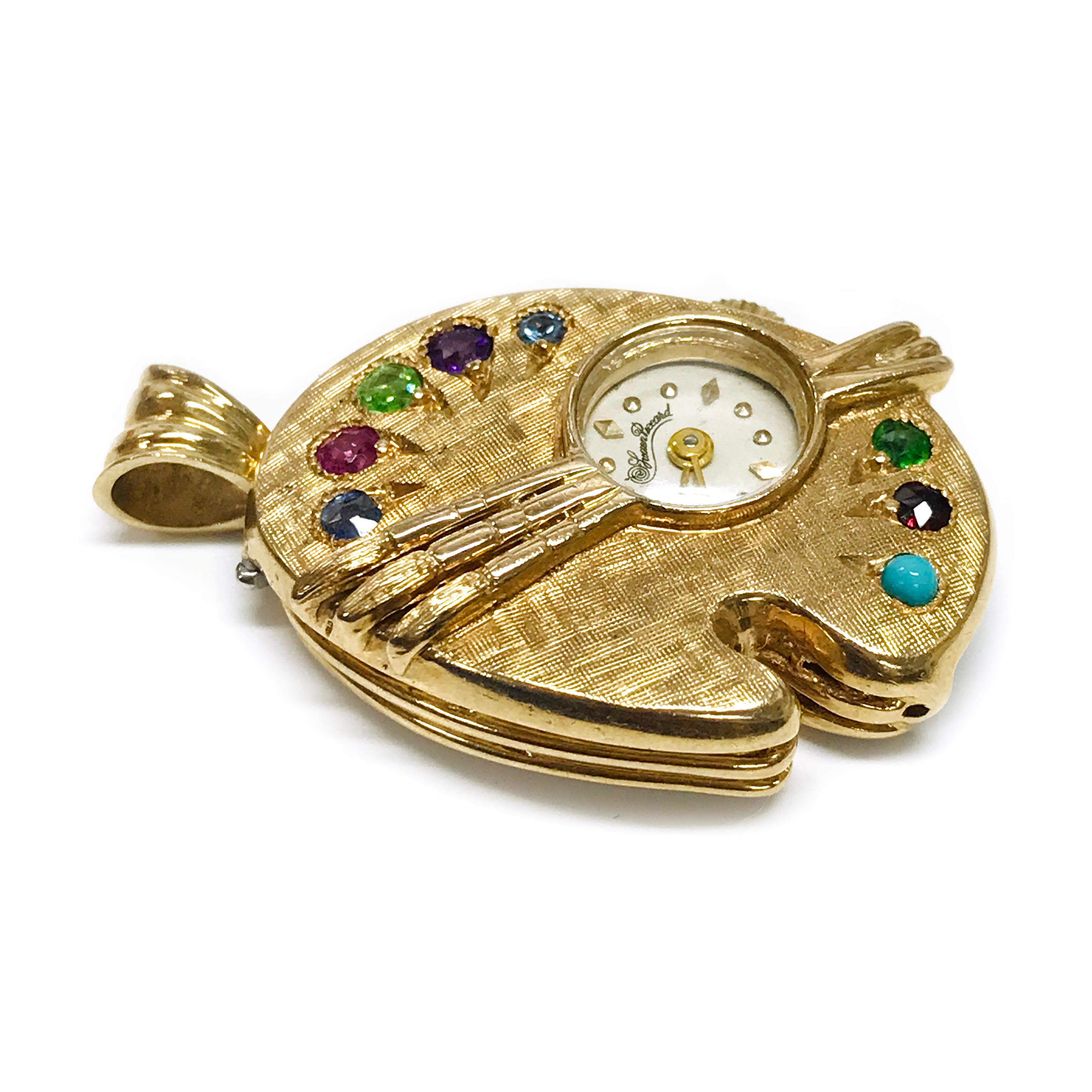 14 Karat Lucien Piccard Multi-Stone Pendant Watch. This is a darling pendant with a colorful array of stones, perfect for an artist or art enthusiast. The pendant is shaped like a painter's palette with a clock set off-center and three brushes set