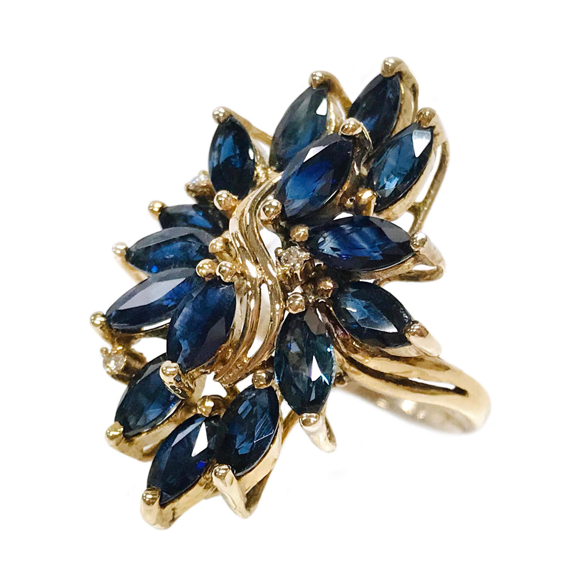 14 Karat Marquise-Cut Blue Sapphire Diamond Cluster Ring. The twisted split band cluster ring features fifteen marquise-cut dark blue sapphires and three round diamonds. All stones are prong-set. Stamped on the inside of the band is 14K 585. The