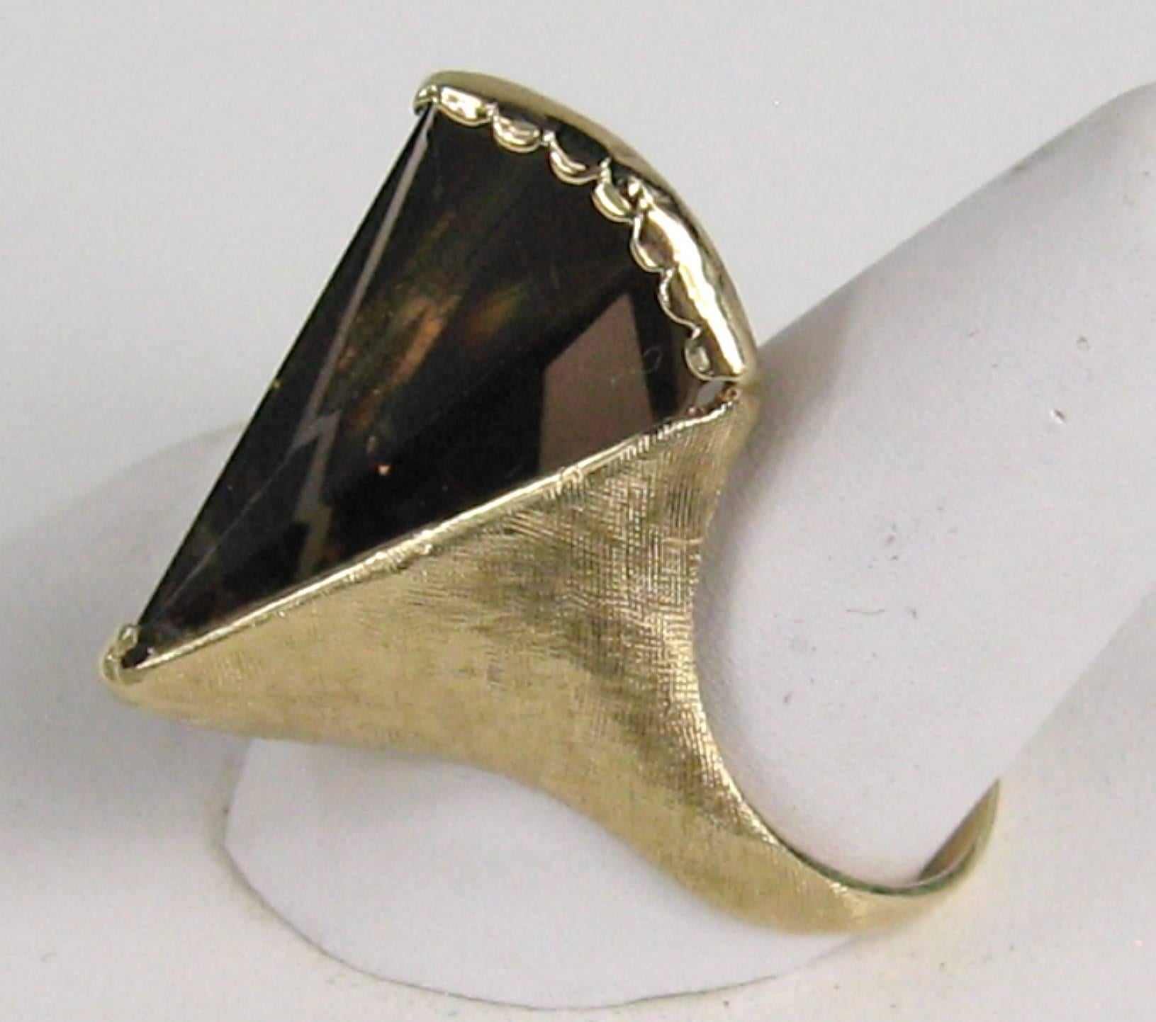 Stunning lines, along with the cut on the smokey topaz. The ring is from the 1960s. Brushed 14K gold. The ring is a size 7.5 and can be sized by us or your jeweler. The stone stands about 1/2 in high. The ring is hallmarked and numbered inside the