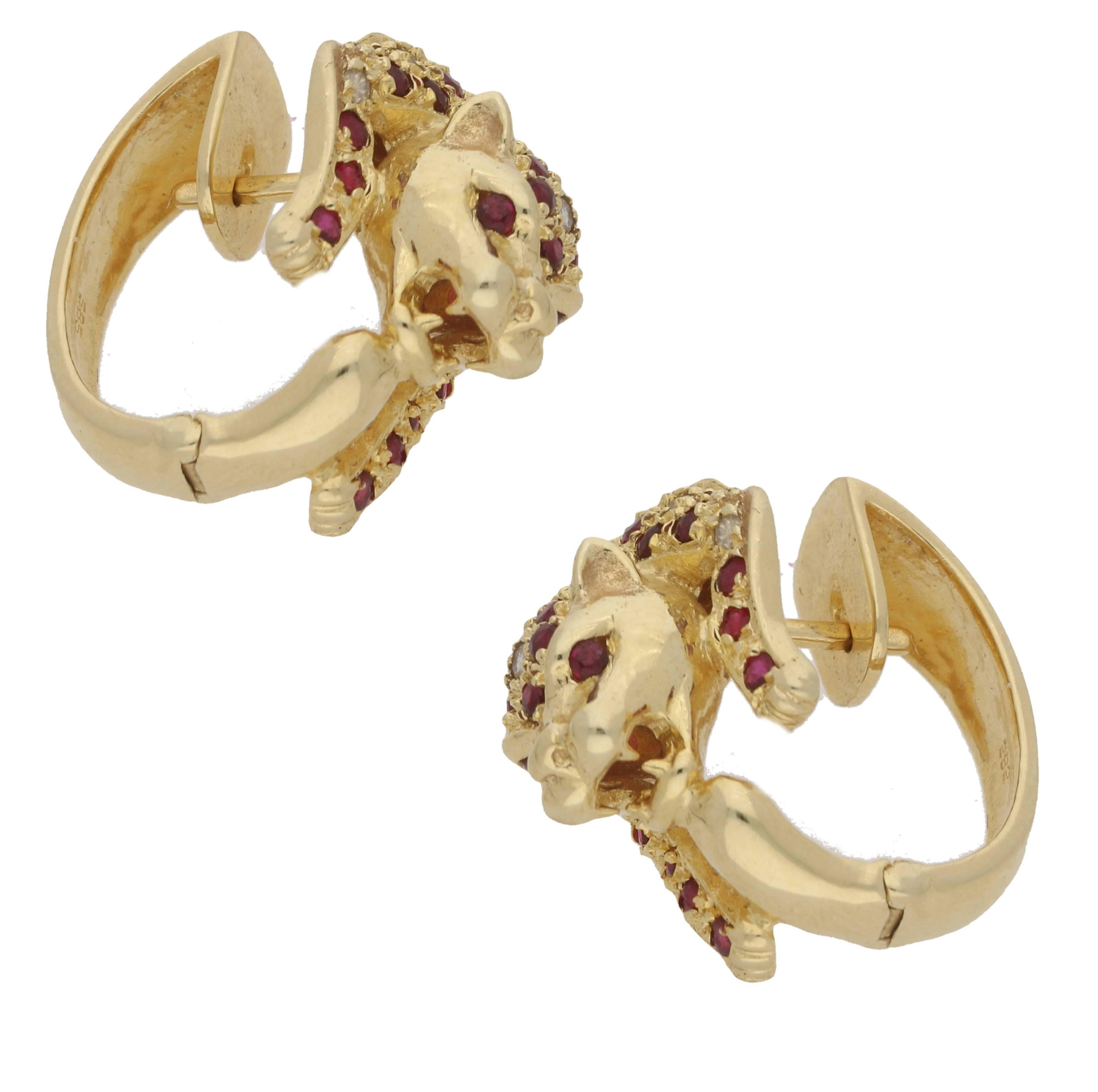 A stunning pair of panther hoop earrings in 14ct yellow gold, featuring a ruby and diamond pave set panther encircling the ear. The earrings are 20.00mm in length and 14.00mm in width and set with 68 round faceted rubies and 14 round brilliant cut