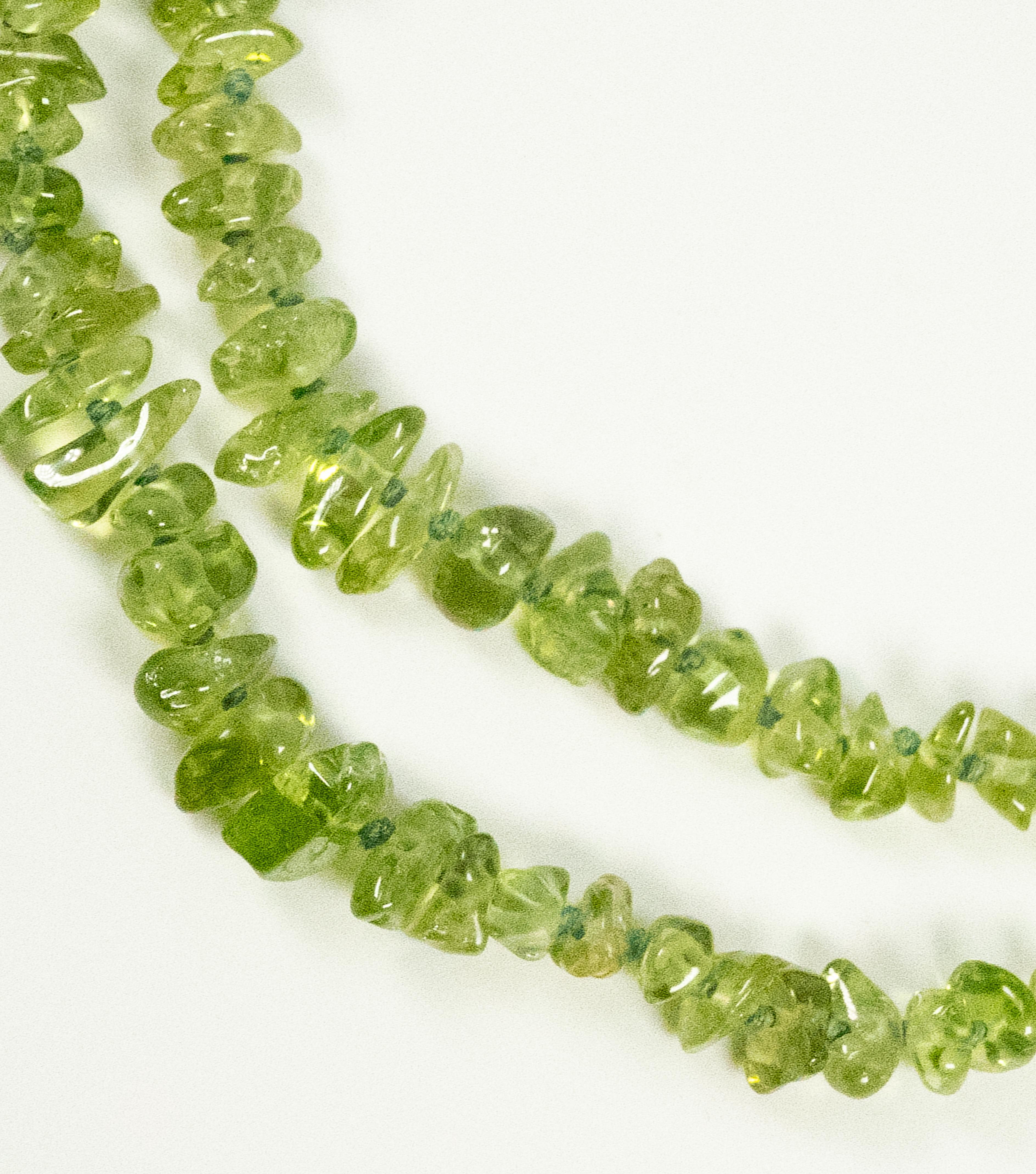 This beautiful double row peridot bead necklace is secured with a yellow gold clasp, stamped 14 Karat, Gumps.