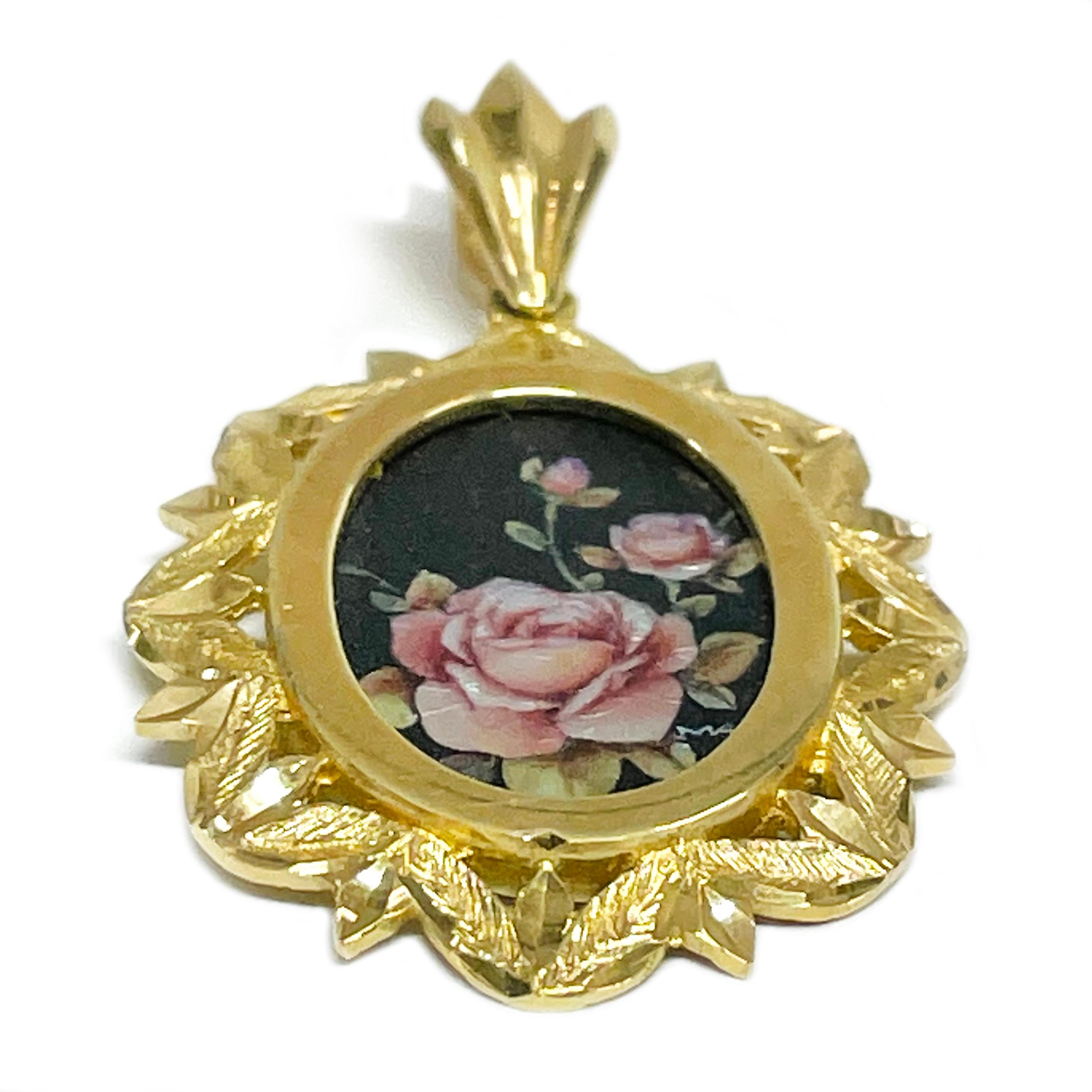 14 Karat Yellow Gold Pinks Roses on a black background Hand Painted on a Mother of Pearl Pendant. The miniature painting is set in a 14 karat gold ornate oval frame with diamond-cut details. The painting is signed by the master artist, CR Charlotte