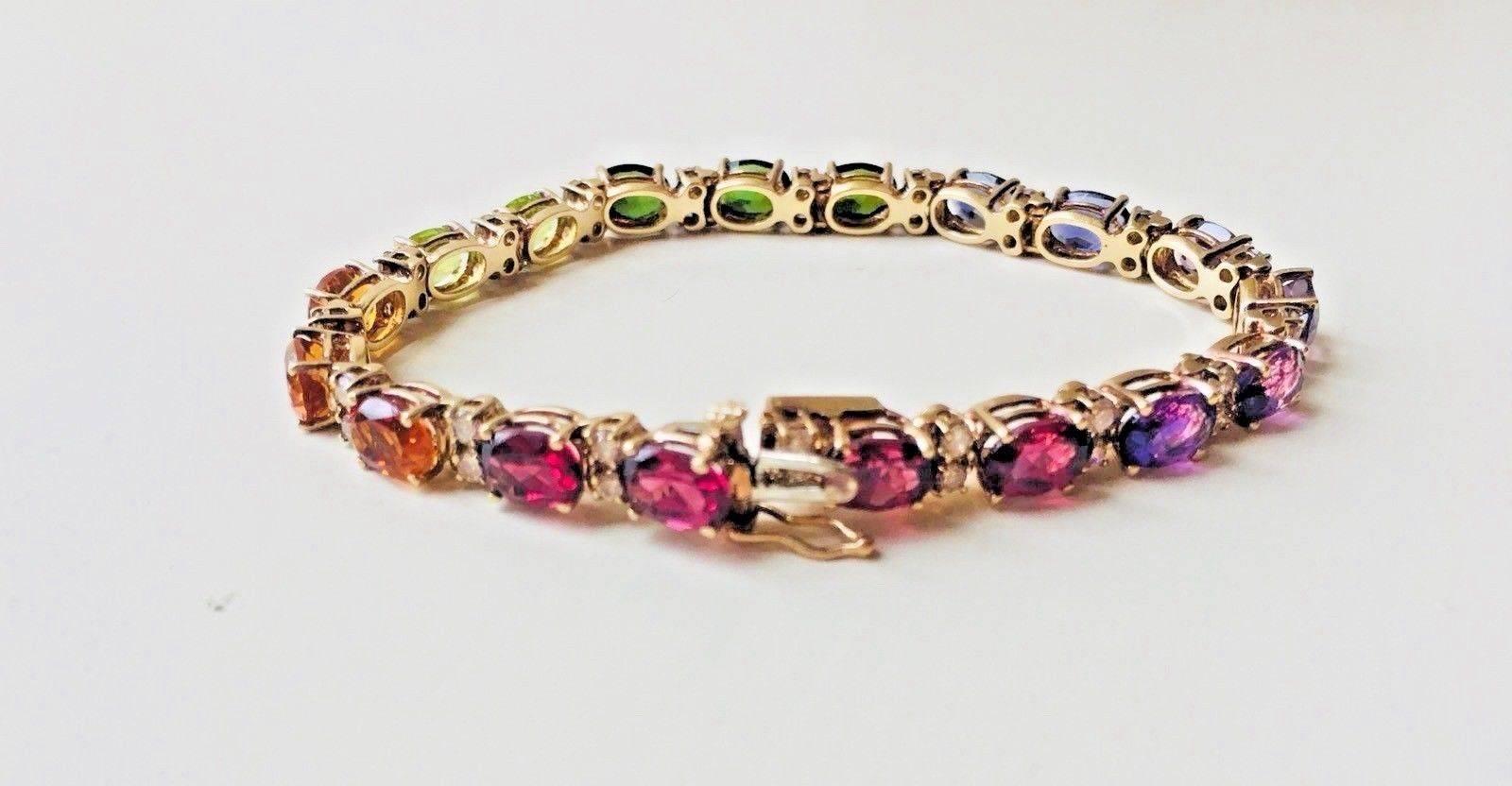 This beautiful gemstone bracelet features 1.45 carats of good quality white round brilliant diamonds, 3.40 carats of oval brilliant amethyst, 1.30 carats of oval brilliant iolite, 2.70 carats of oval modified brilliant green tourmaline, 1.90 carats