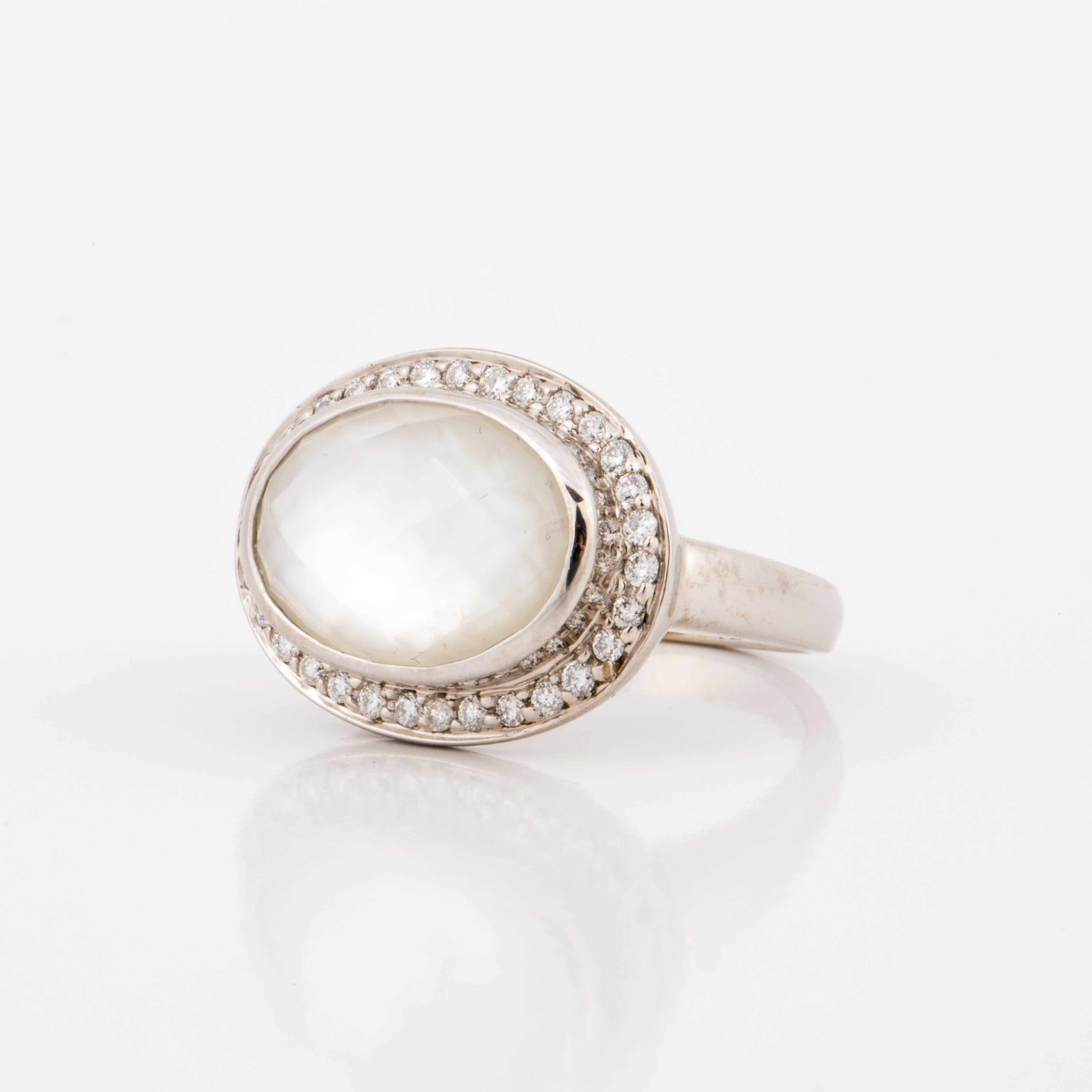 Mazza ring composed of 14K white gold with a faceted oval rock crystal backed with mother-of-pearl and framed with runs diamonds. The diamonds total 0.31 carats.  Presentation area measures 7/8 inches by 9/16 inches.  Ring is currently a size 7.