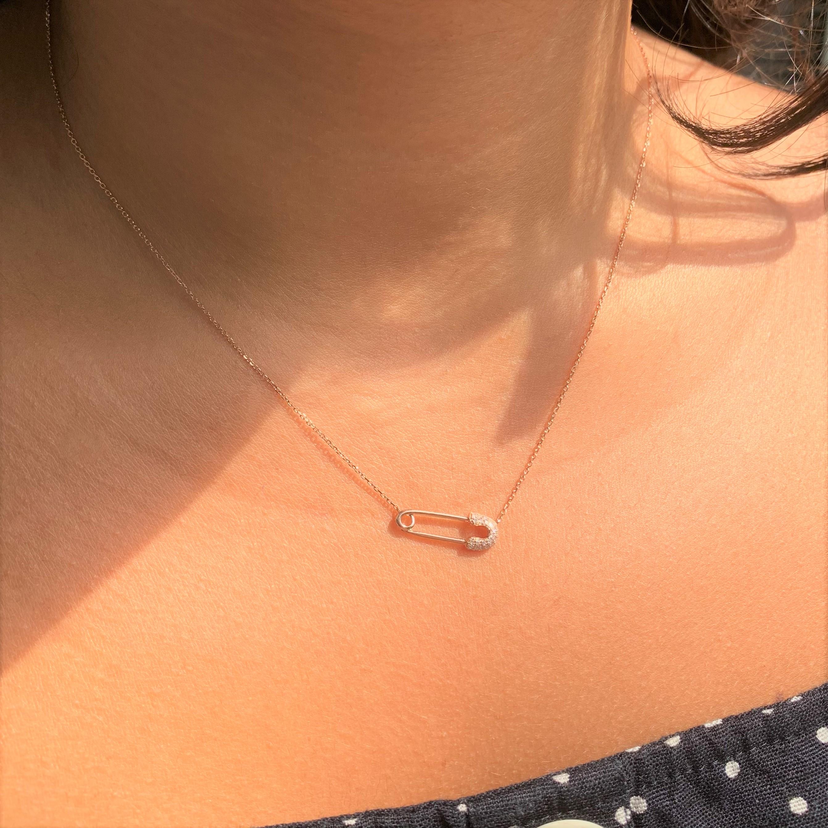 This is an adorable safety pin necklace crafted of 14K Rose Gold, featuring 23 round natural White Diamonds weighing 0.07 carats. Gold weight is 2.11 grams. Chain is adjustable 16