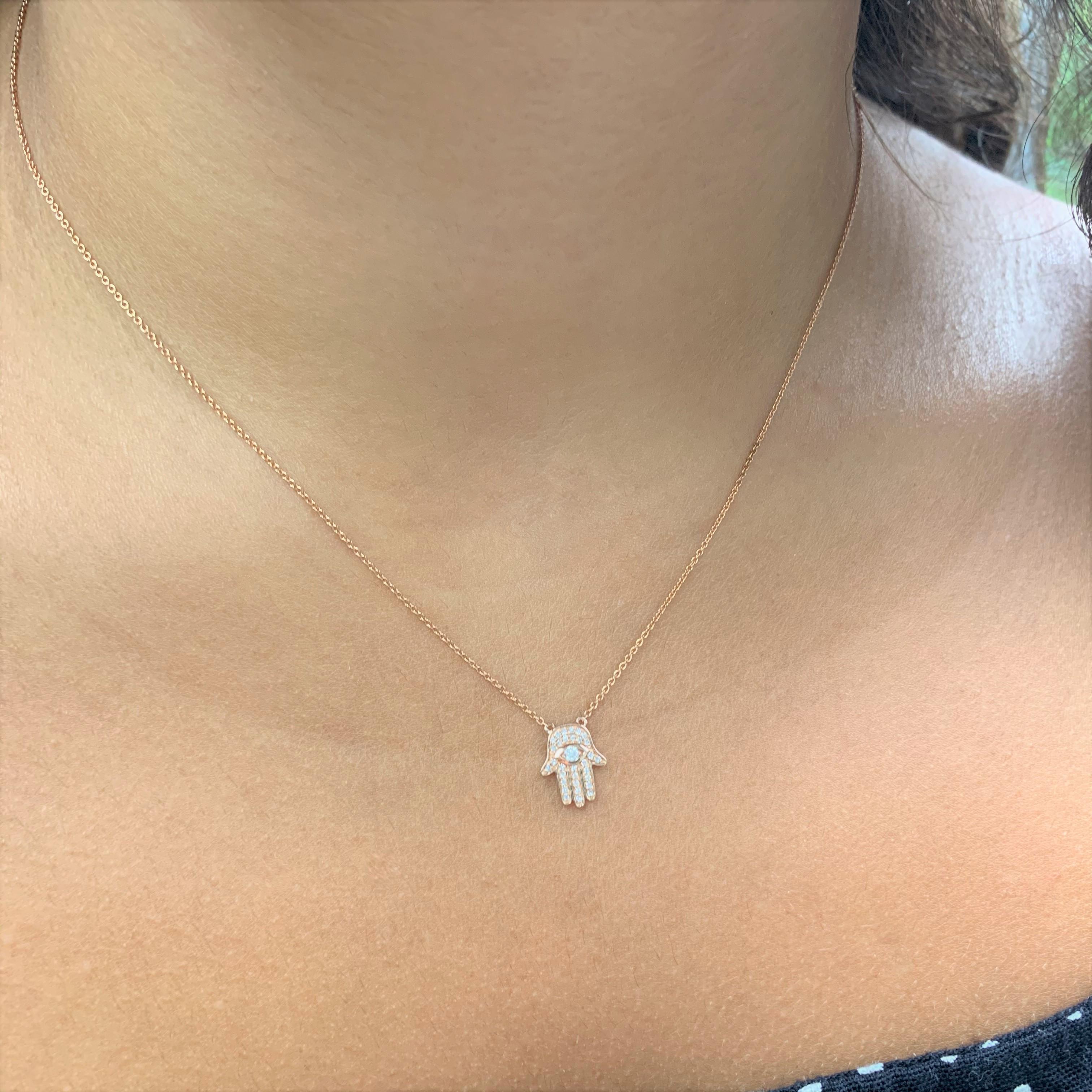 Feel Protected and Guarded with this Hamsa Hand of God Necklace! Crafted of 14K Gold this pendant features 0.11 carats of natural white Diamonds  on an 16