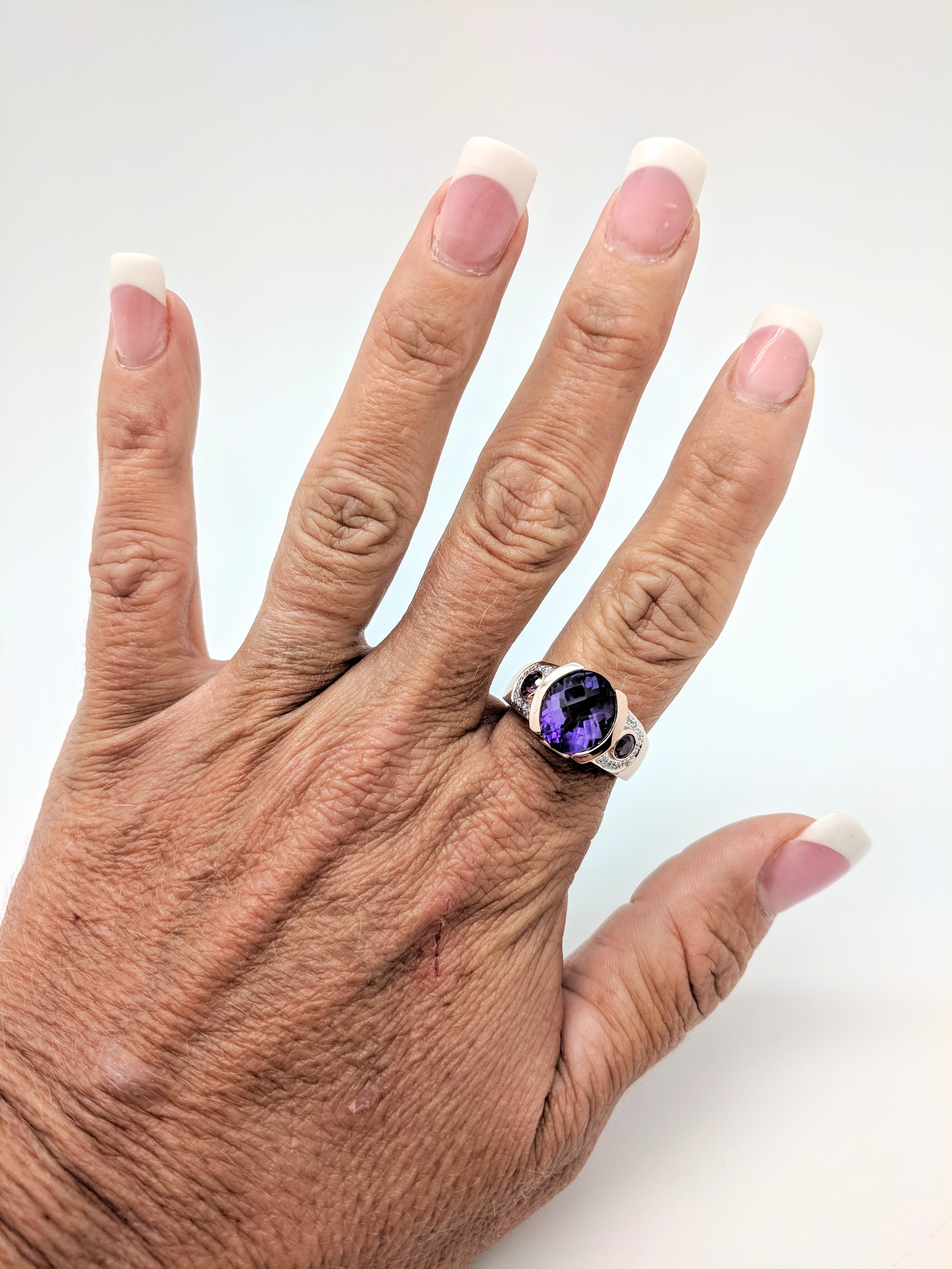 You are viewing a beautiful amethyst and diamond right hand ring. Any woman would love to add this piece to their collection! This ring is crafted from 14k rose gold and weighs 8.9 grams. It features (1) 12x10mm half bezel set oval prism cut