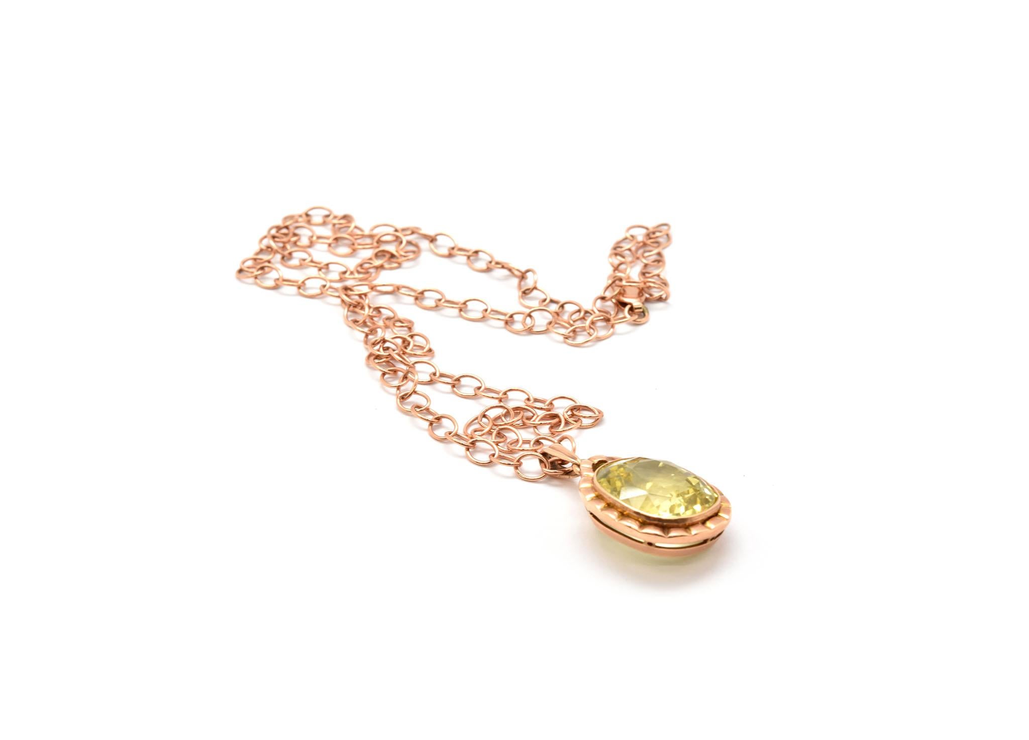 A stunning lemon quartz stone is set into a 14k rose gold pendant setting. The quartz measures 13x15mm, and the pendant measures 29x17mm. The pendant slides along a 14k rose gold chain that measures about 18 inches in length. The necklace weighs