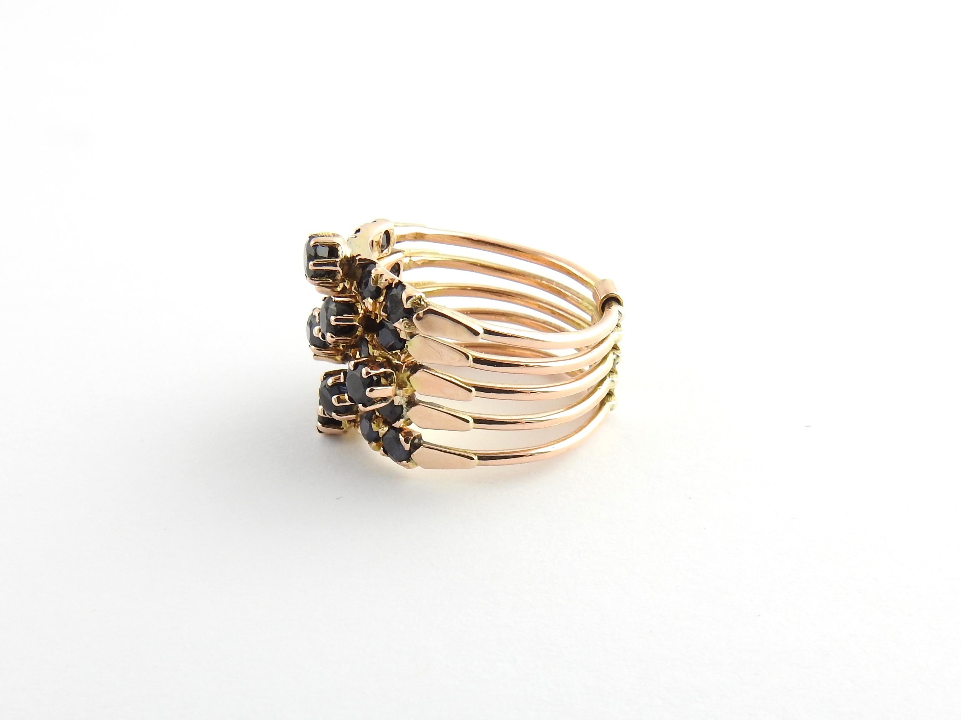 Vintage 14 Karat Rose Gold and Sapphire Multi Band Ring Size 4.75

This stunning five band ring features 25 blue sapphires set in beautifully detailed 14K rose gold. Bands are connected with a yellow gold bar.

Width: 15 mm. Shank: 9 mm.

Ring Size: