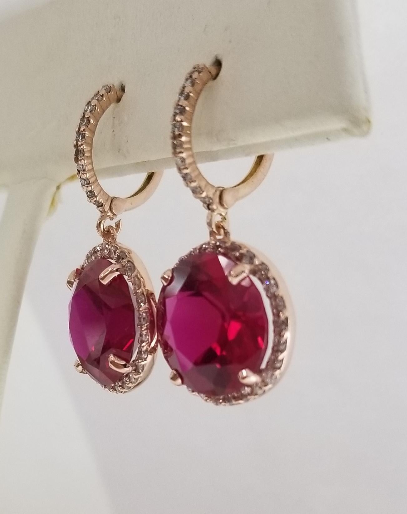 14 karat rose gold diamond hoop with synthetic ruby earrings, containing  72 round full cut diamonds weighing .65pts. surrounding 2 round synthetic rubies weighing 14.05cts. 