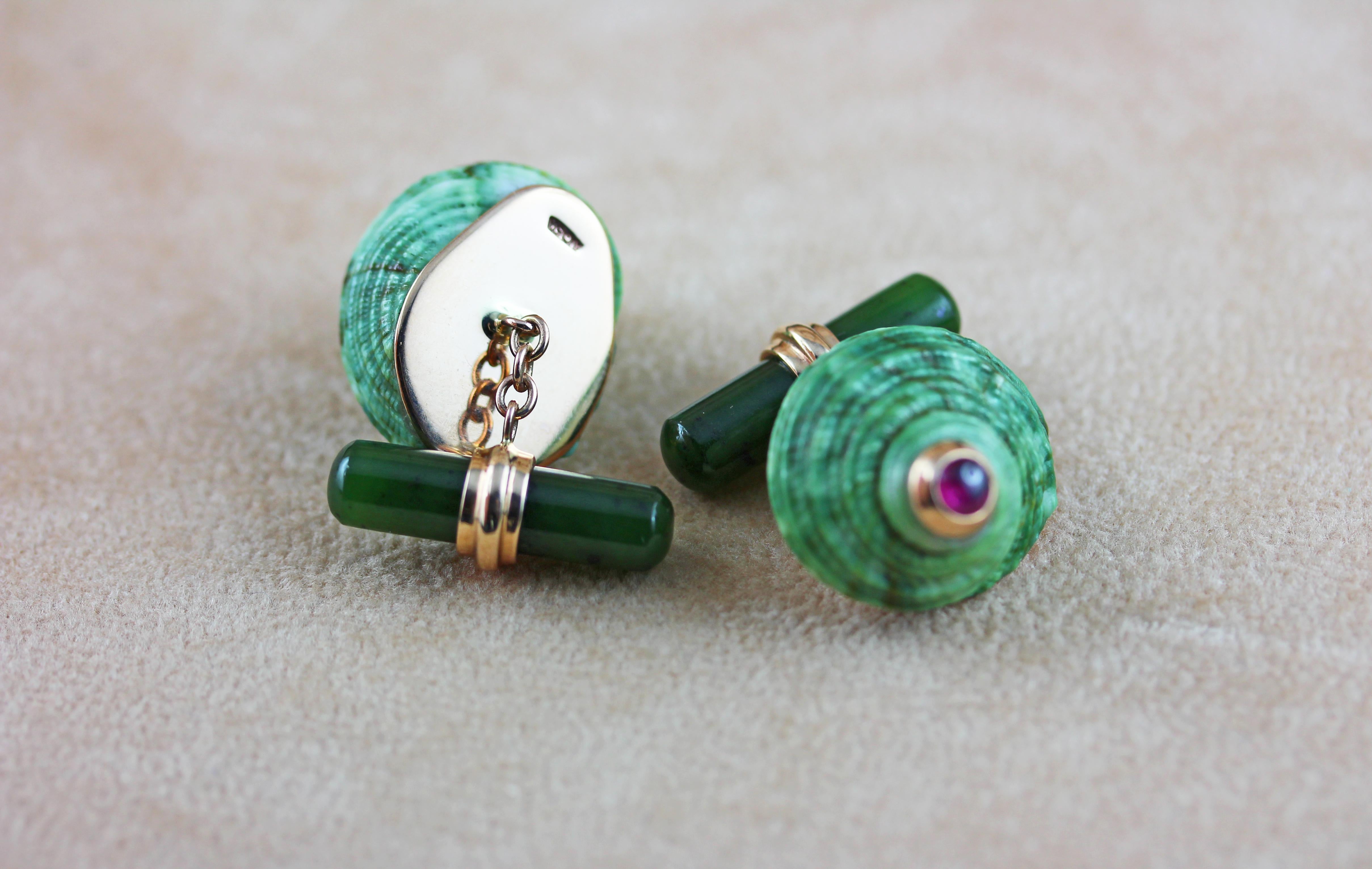 The striking green shade and natural texture of the  shell, adorned with a cabochon ruby at the top, is the protagonist of the front face of this elegant pair of cufflinks, which also features a cylindrical toggle in jade stone, whose green matches