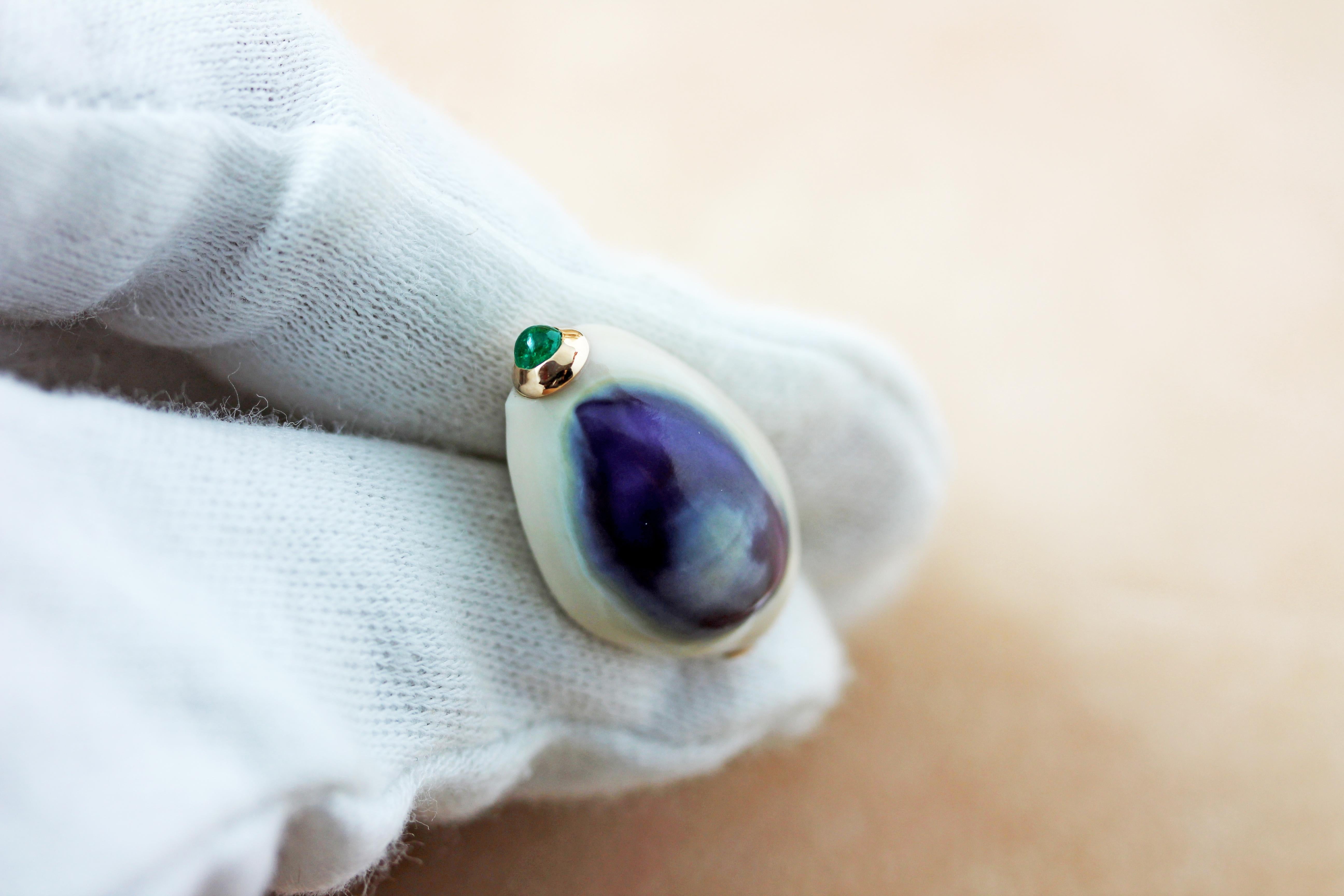 The natural purple and white pattern of this shell is the protagonist of the front face of this elegant pair of cufflinks, each shell is adorned with a cabochon emerald, a malachite bar is used for the toggle.
Mounting in rose gold 14