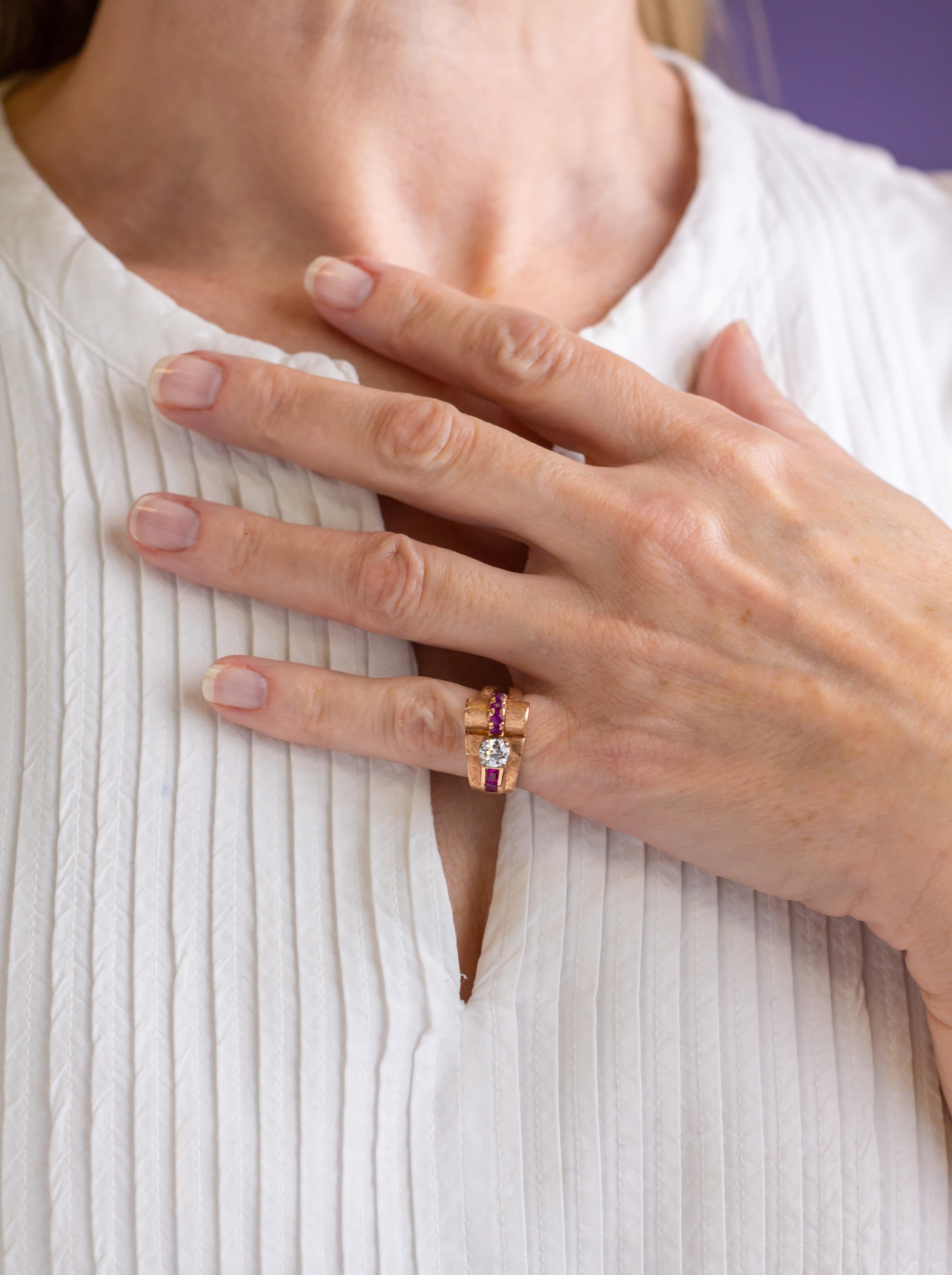 A beautiful 1950s asymmetric diamond and ruby cocktail ring set in 14 karat rose gold. This piece was likely manufactured in the United States in the 1950s and features a central semi modern brilliant cut diamond weighing 0.43 carat, of I colour and