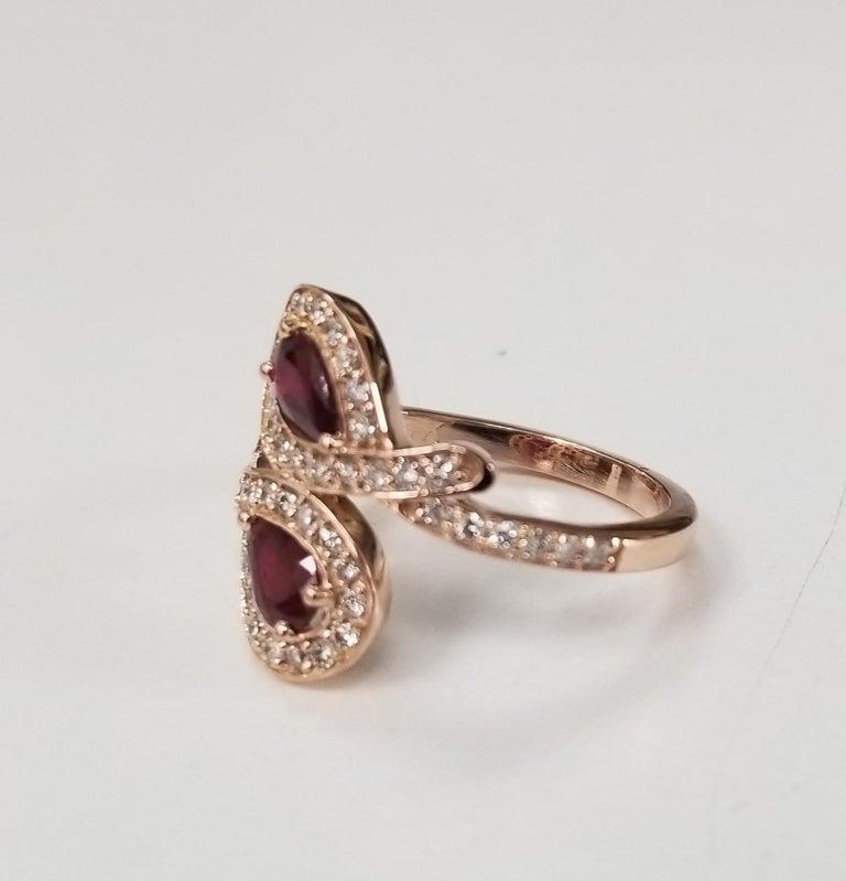 14k rose gold ruby and diamond ring, containing 2 pear shape rubies of gem quality weighing .84pts. and 48 round full cut diamonds of very good quality weighing .50pts.  This ring is a size 7 but we will size to fit for free.